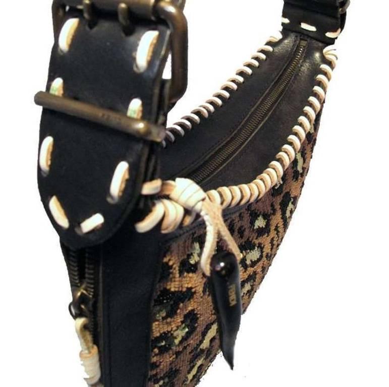 Diese atemberaubende Fendi Umhängetasche ist in ausgezeichnetem Zustand. Das Äußere zeigt ein wunderschönes Leopardenmuster aus Pailletten und Perlen, das mit schwarzem Leder besetzt ist. Die Kanten sind mit gewebtem weißem Leder verarbeitet und der