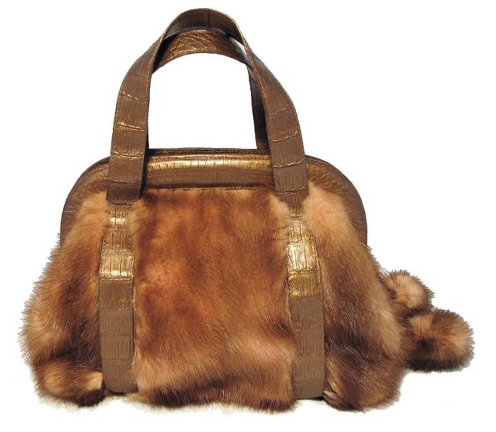 This fabulously stylish Nancy Gonzalez handbag is in pristine condition. The exterior features beautiful pink mink fur trimmed with bronze crocodile leather. The full zipper closure opens to a light beige suede interior that holds one side zippered