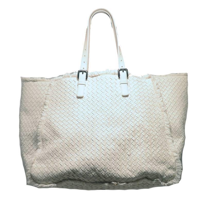 RARE Bottega Veneta white woven tote bag in excellent condition.  Woven white leather exterior trimmed with canvas fringe along all exterior edges  Double Adjustable buckle straps are strong and fit to suit your preference.  White canvas lined