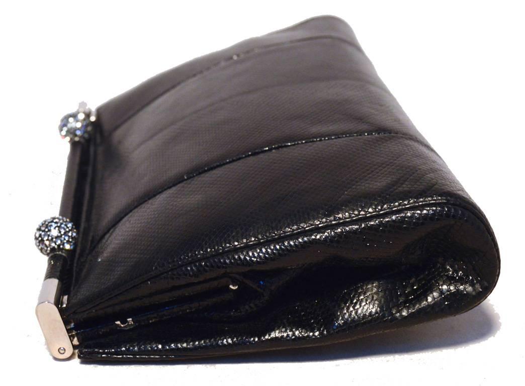 BEAUTIFUL Vintage Judith Leiber black lizard clutch in excellent condition.  Black lizard leather exterior trimmed with silver hardware and 2 swarovski crystal ball details.  Top lifting bar closure opens to a black satin lined interior that holds 1