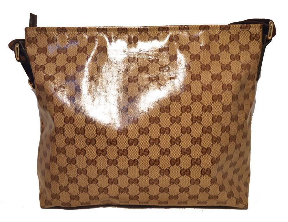 Stunning GUCCI monogram shoulder bag in excellent condition.  Coated monogram canvas exterior trimmed with a woven brown adjustable shoulder strap.  Top zipper closure opens to a brown cotton lined interior that holds one side zippered pocket.  No