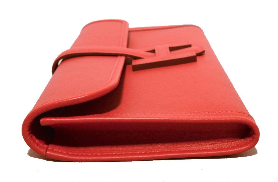 GORGEOUS HERMES red swift leather jige clutch in excellent condition.  Red swift leather in timeless Jige design. Front strap closure opens to a matching red leather lined interior.  Excellent condition. No stains, smells, or scuffs. Clean corners,