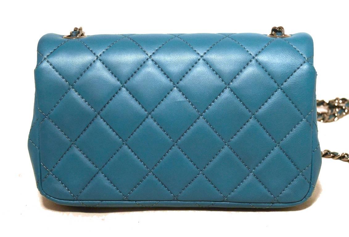 BEAUTIFUL Chanel teal extra mini classic flap in excellent condition.  Teal quilted lambskin leather exterior trimmed with shining silver hardware and signature woven chain and leather shoulder strap.  Front cc twist closure opens single flap style
