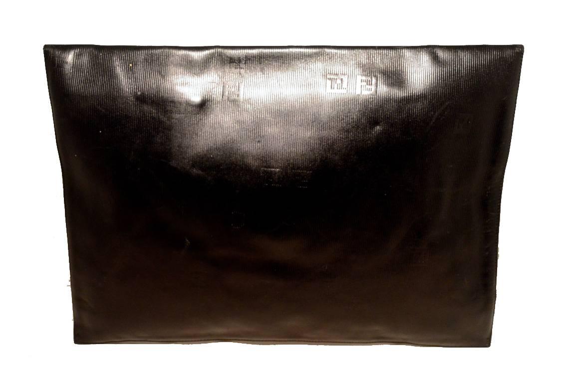 RARE COLLECTIBLE Fendi black oversized envelope clutch in excellent vintage condition.  Black textured leather embossed with the Fendi logo trimmed with a red and yellow centered eye catching circle. Snap closure opens to a black leather lined
