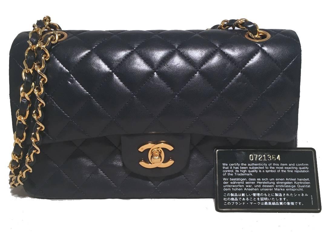 Precioso clásico vintage Chanel de doble solapa en muy buen estado. Exterior de piel de cordero azul marino oscuro con el característico estampado acolchado de rombos, ribeteado con brillantes herrajes dorados. La cadena tejida y la bandolera de