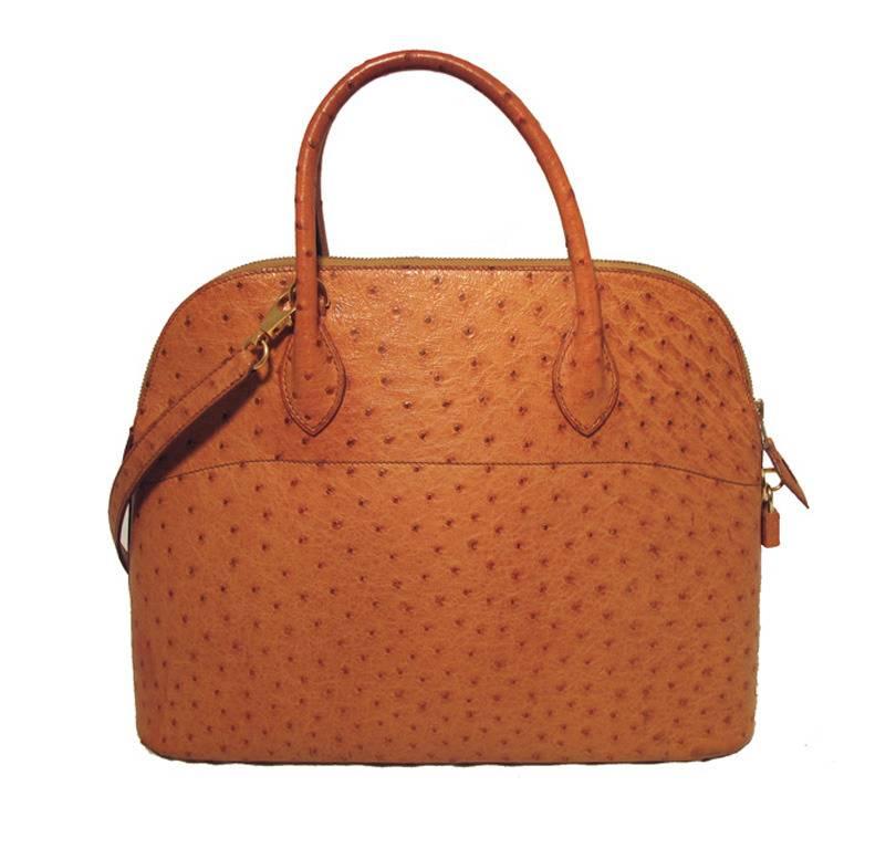 Authentic Hermes ostrich bolide bag in very good condition. Exterior features stunning tan ostrich leather and is perfectly trimmed with gold hardware. The top zipper closure opens to a tan lambskin interior that holds 1 side slit pocket. There are