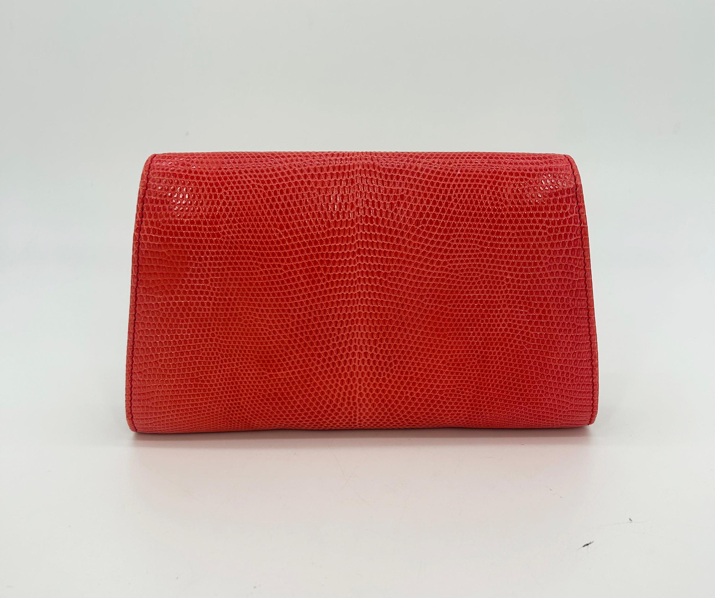 Vintage Judith Leiber Red Lizard Gemstone Front Clutch in very good condition. Beautiful cherry red lizard leather exterior in unique envelope style design trimmed with gold hardware and multi gemstone embellished front accent featuring pearls,