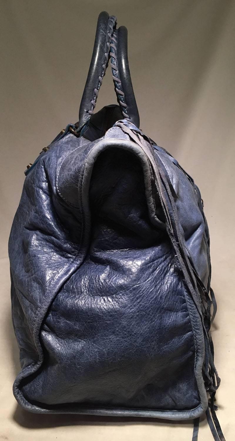 Balenciaga Blue Leather XL City Bag Tote in excellent condition.  Blue leather exterior trimmed with bronze leather and leather fringe strips and a front zippered pocket.  Top zipper closure opens to a black canvas lined interior that holds one side