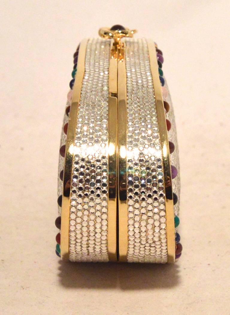 STUNNING JUDITH LEIBER Swarovski crystal oval minaudiere in excellent condition.  Clear Swarovski crystals surround the exterior of this piece.  Gold hardware and multi-colored round stones trim the edges of the outside.  Top button closure opens to