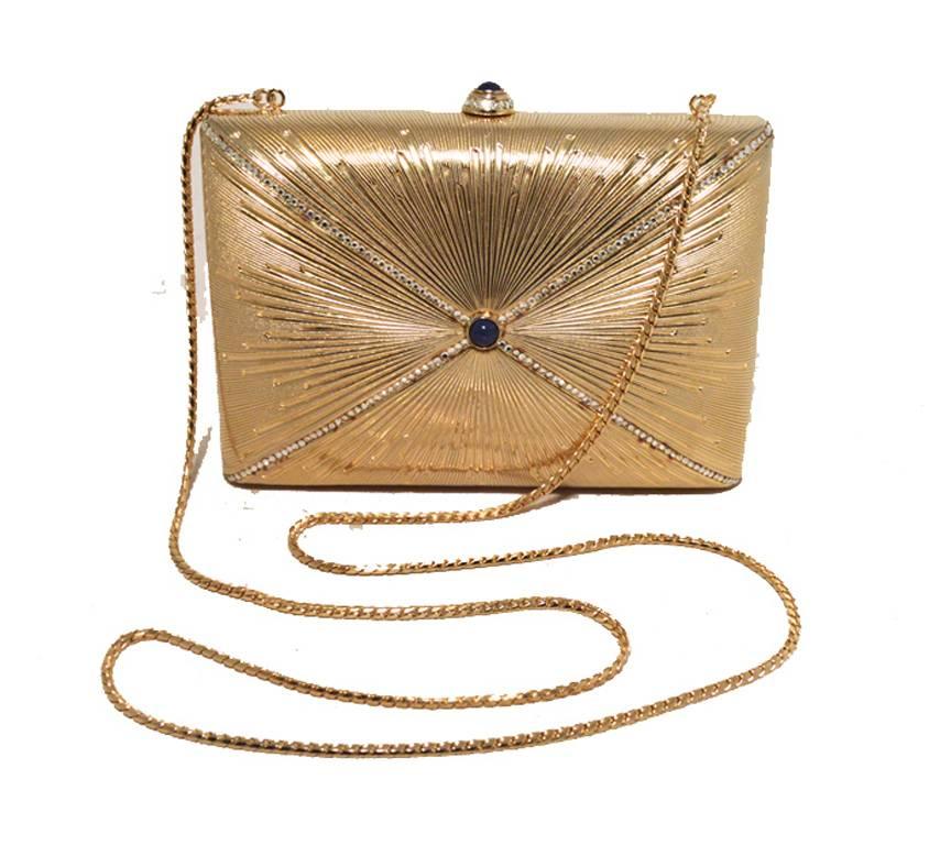 BEAUTIFUL JUDITH LEIBER VINTAGE Swarovski crystal gold starburst minaudiere evening bag in excellent condition.  Solid gold exterior with clear swarovski crystals and a royal blue gemstone in the left of a stunning starburst design along both sides