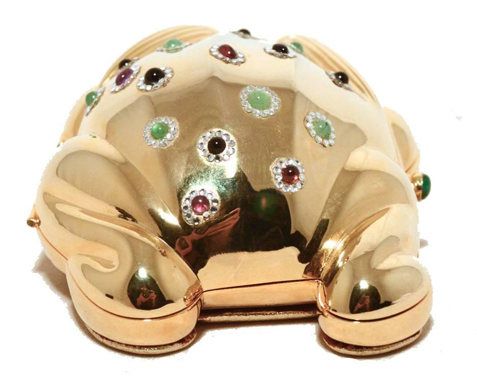 ADORABLE JUDITH LEIBER gold frog minaudiere in excellent condition.  Gold frog formed metal exterior with various precious gemstones on the back body surrounded by clear Swarovski crystals.  Side button closure opens to a gold leather lined interior