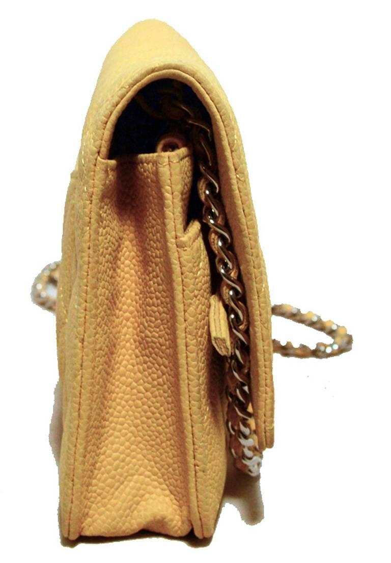 CHANEL rare mustard yellow wallet on a chain in very good condition. Mustard yellow quilted leather exterior trimmed with silver hardware and woven chain and leather shoulder strap. Single flap style snap closure opens to a navy blue nylon and