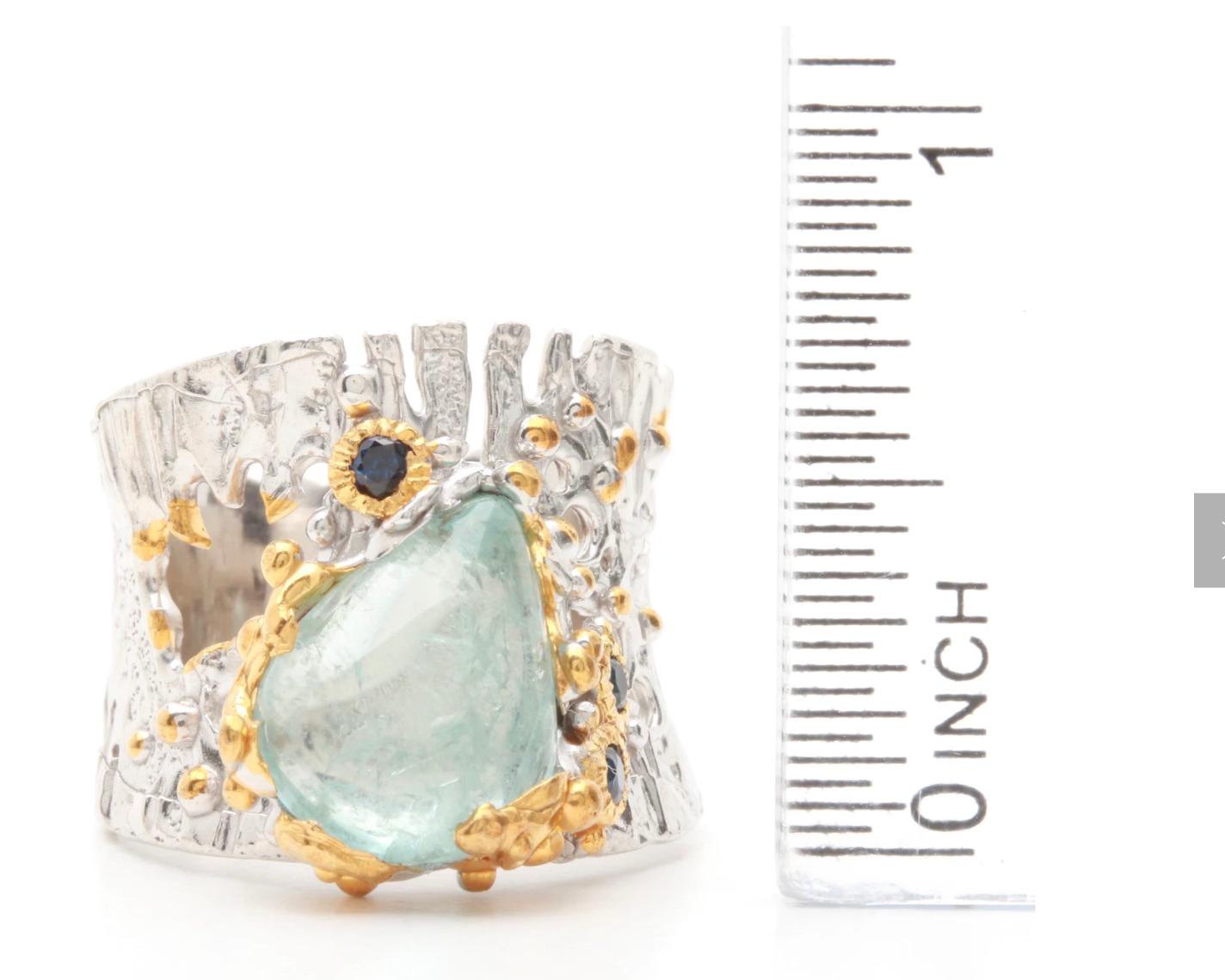 A Stunning artist designed Brutalist Sterling Silver and Vermeil, Pear shaped Aquamarine Cabochon Ring. with 3 round faceted sapphires and gold plate beads and trim.. 
The gemstones showcase the Unique Organic Openwork Live Edge sterling silver
