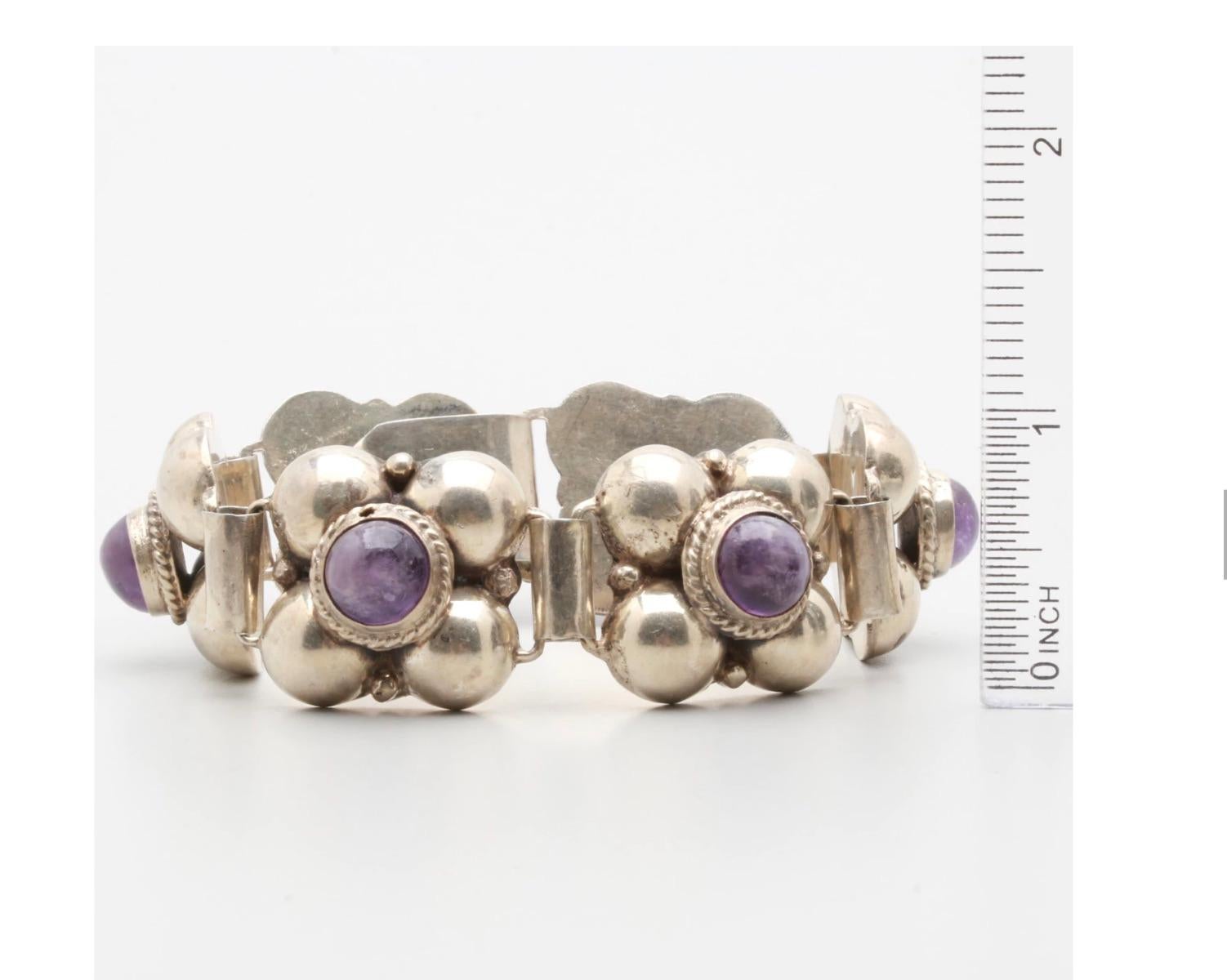 A Mexico sterling silver beautiful large amethyst cabochon link bracelet.
The bracelet was made in Mexico, and features 6 linked segments composed of half-spheres topped by 6 bezel-set amethyst with rope detail, a hook and eye closure.   Surely