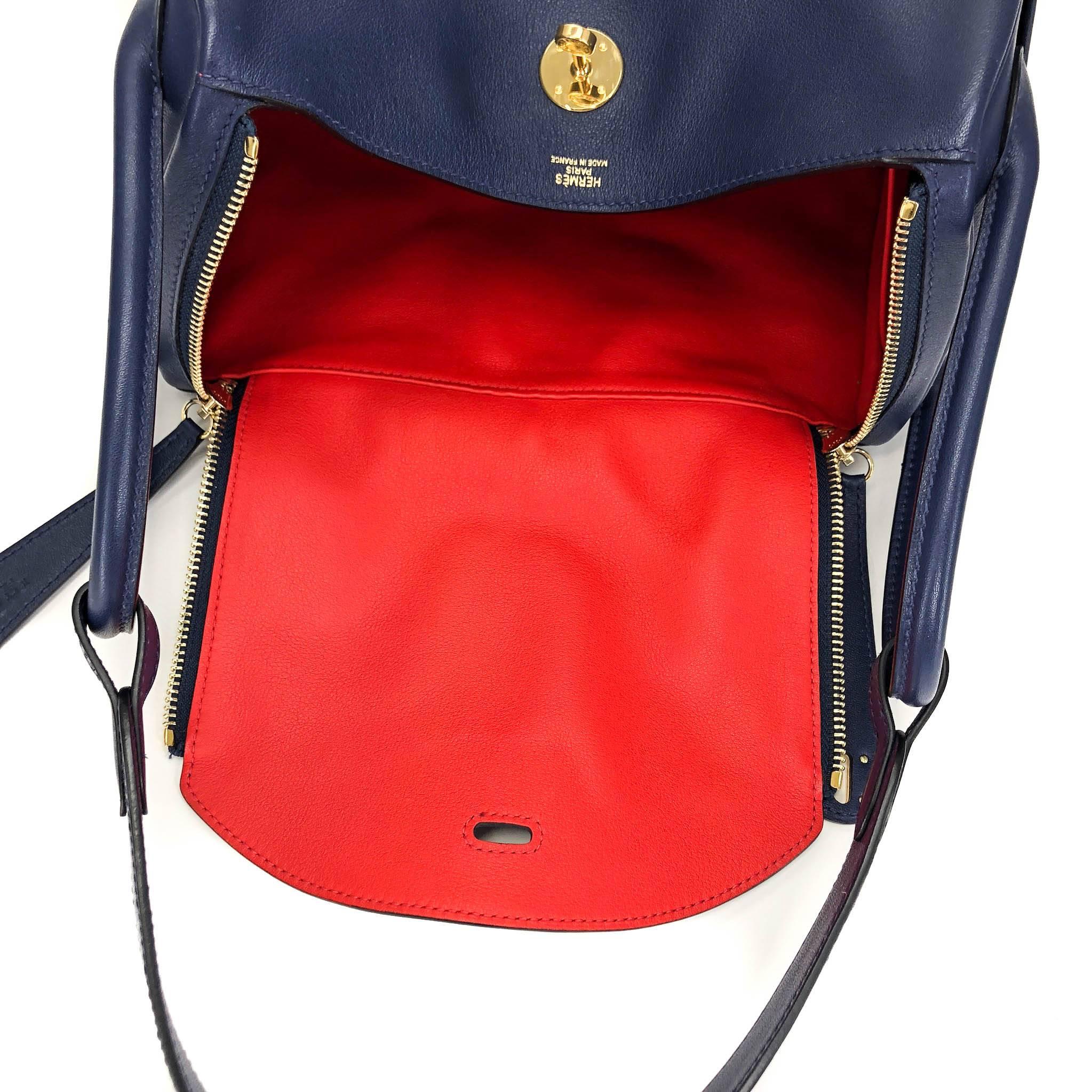 The Hermes Lindy 30 Handbag, with its unique silhouette and generous interior, is the perfect companion for shopping, running errands, or it could even make a chic diaper bag for a designer mom. In Blue Nuit- a stunning navy shade, the rouge tomate