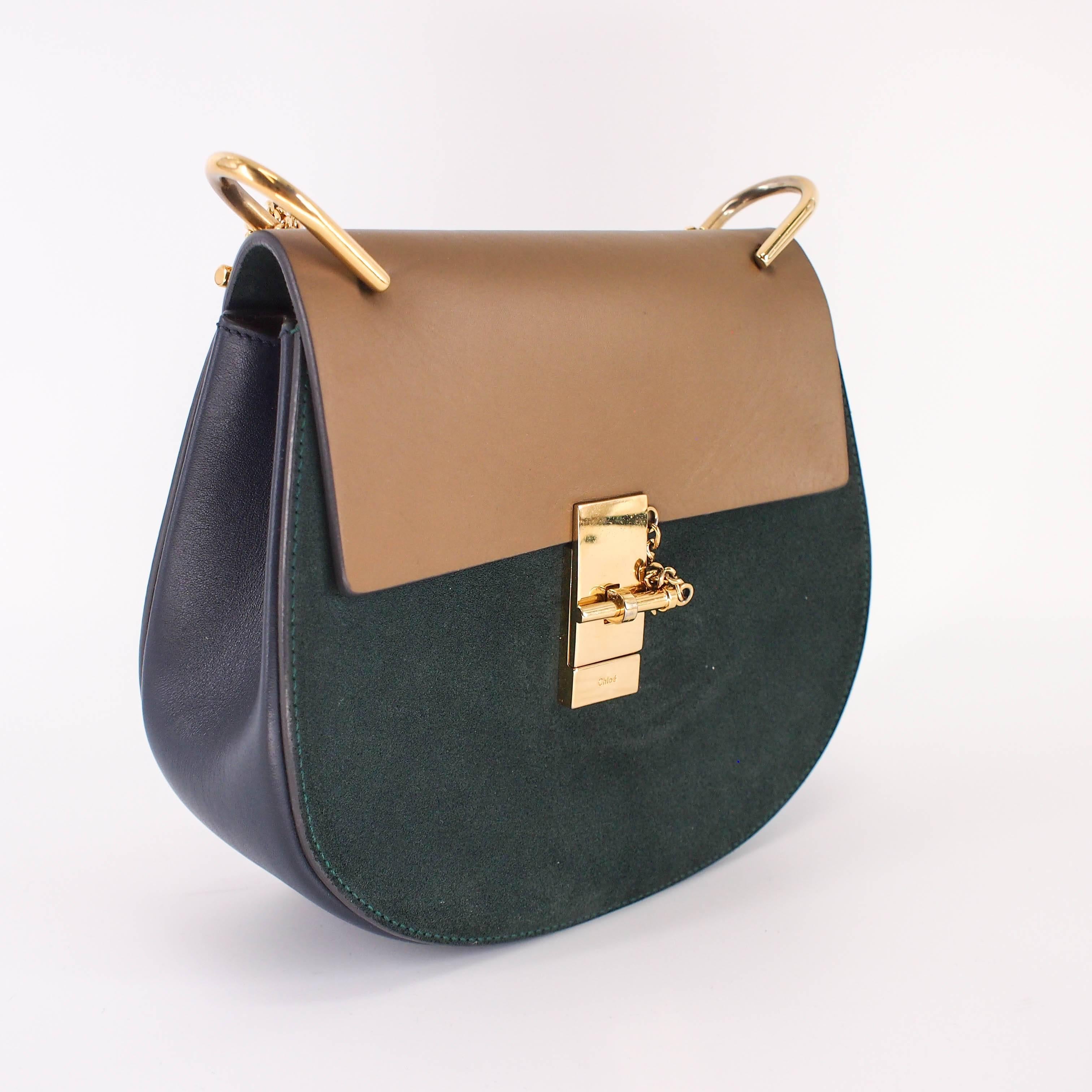 You'll look chic and lovely with this Chloe Shoulder Bag by your side. The gold chain shoulder strap is a beautiful detail with classic navy, forest green, and caramel brown colors of the exterior. The interior features one flap pocket for anything