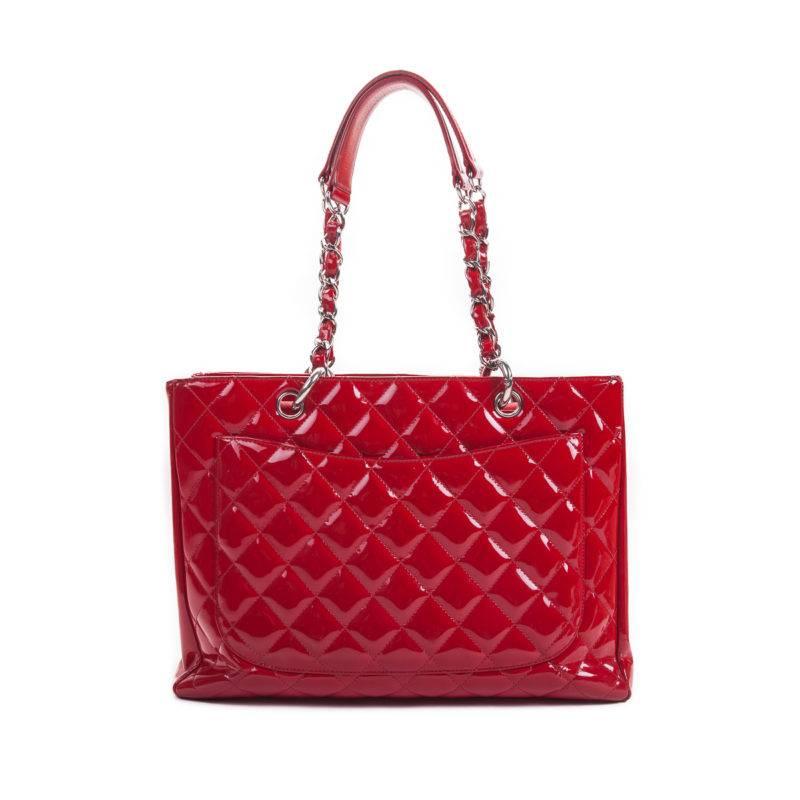This Chanel patent tote is spacious as it has a middle zipper pocket that divides the interior into two open compartments. The embossed interlocking CC accent, chain handles, and quilted design are all features indicative of classic Chanel chicness