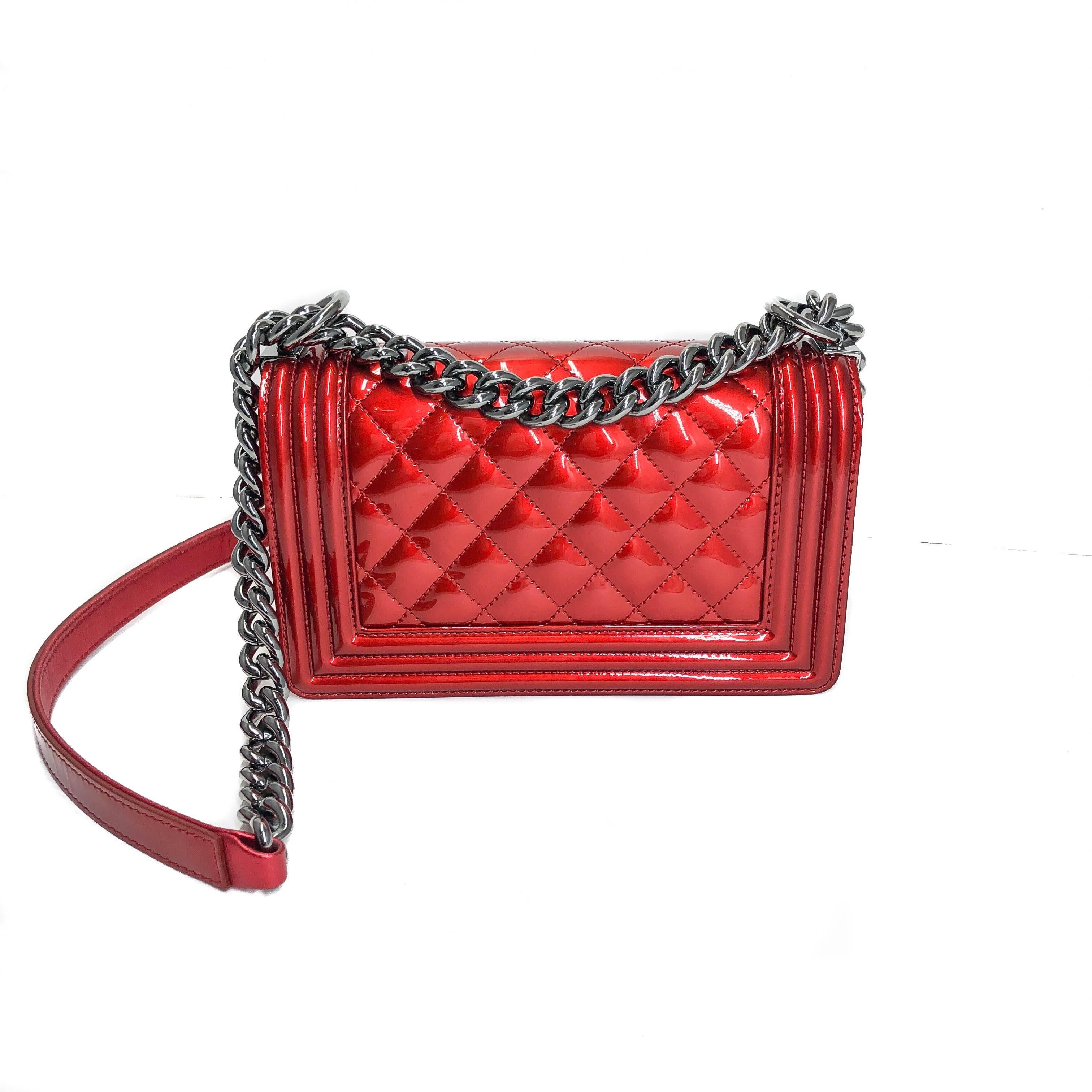 This stylish Small Red Patent Boy Bag is sure to make you stand out in a crowd. Join the ranks of fashion royalty by dressing up your everyday essentials in a Chanel Boy Bag. The interior features one flat pocket for those items you want to keep