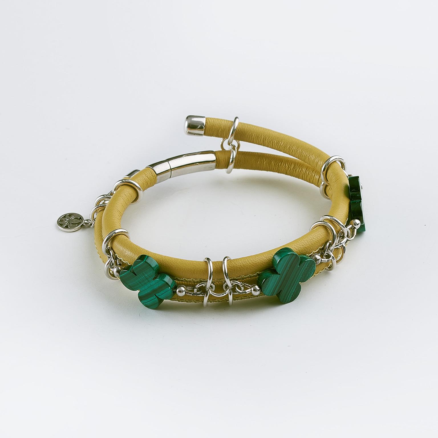 The yellow stitched leather double bangle bracelet made with three malachite clovers cut gemstones and connecting by silver links and a barrel lock. 

Length: 8.0 in ( 21.0 cm )

Malachite clover cut 0.7 x 0.7 in ( 17.0 x 17.0 mm )   
Yellow