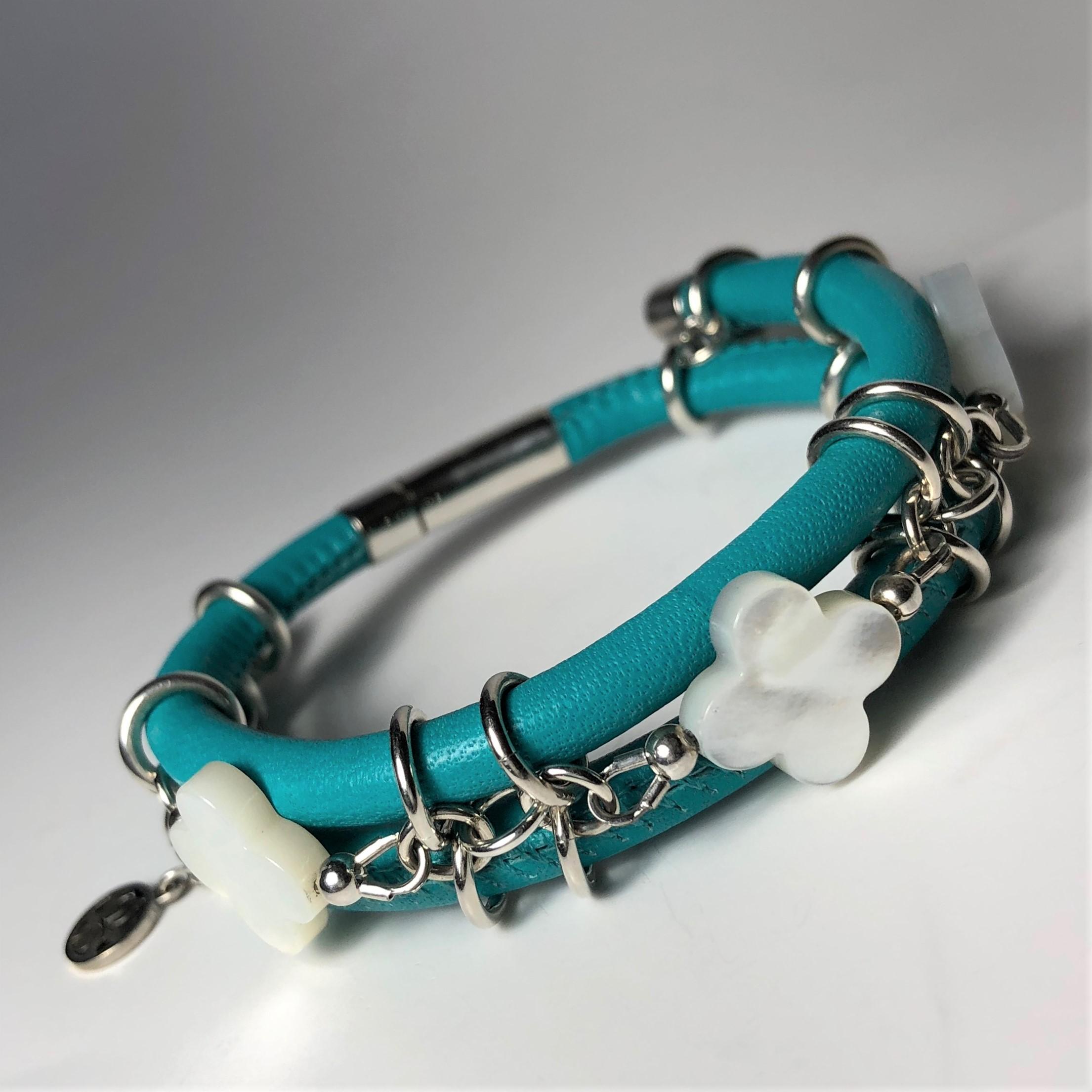 The turquoise stitched leather double bangle bracelet made with three mother of pearls clovers cut gemstones and connecting by silver links and a barrel lock. 

Length: 7.0 in ( 18.0 cm )

Mother of pearls clover cut 0.54 x 0.54 in ( 14.0 x 14.0 mm