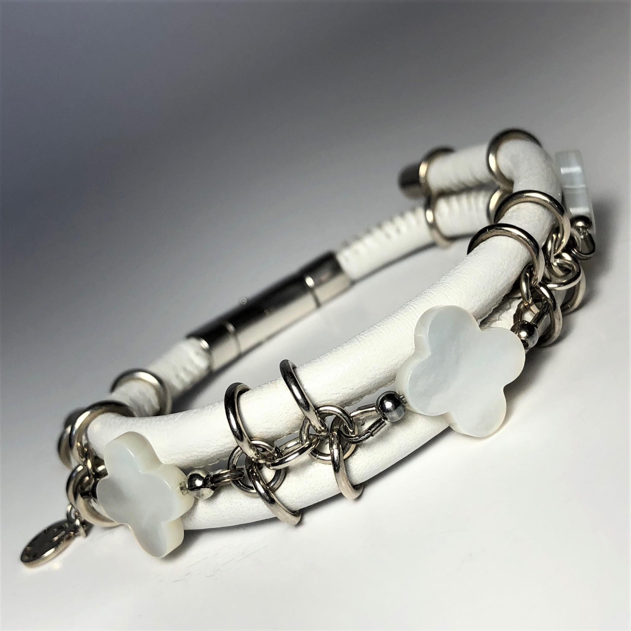 The white stitched leather double bangle bracelet, made with three mother-of-pearls clovers cut gemstones and connecting by silver links and a barrel lock. 

Length: 7.5 in ( 19.0 cm )

Mother of pearls clover cut 0.54 x 0.54 in ( 14.0 x 14.0 mm )  