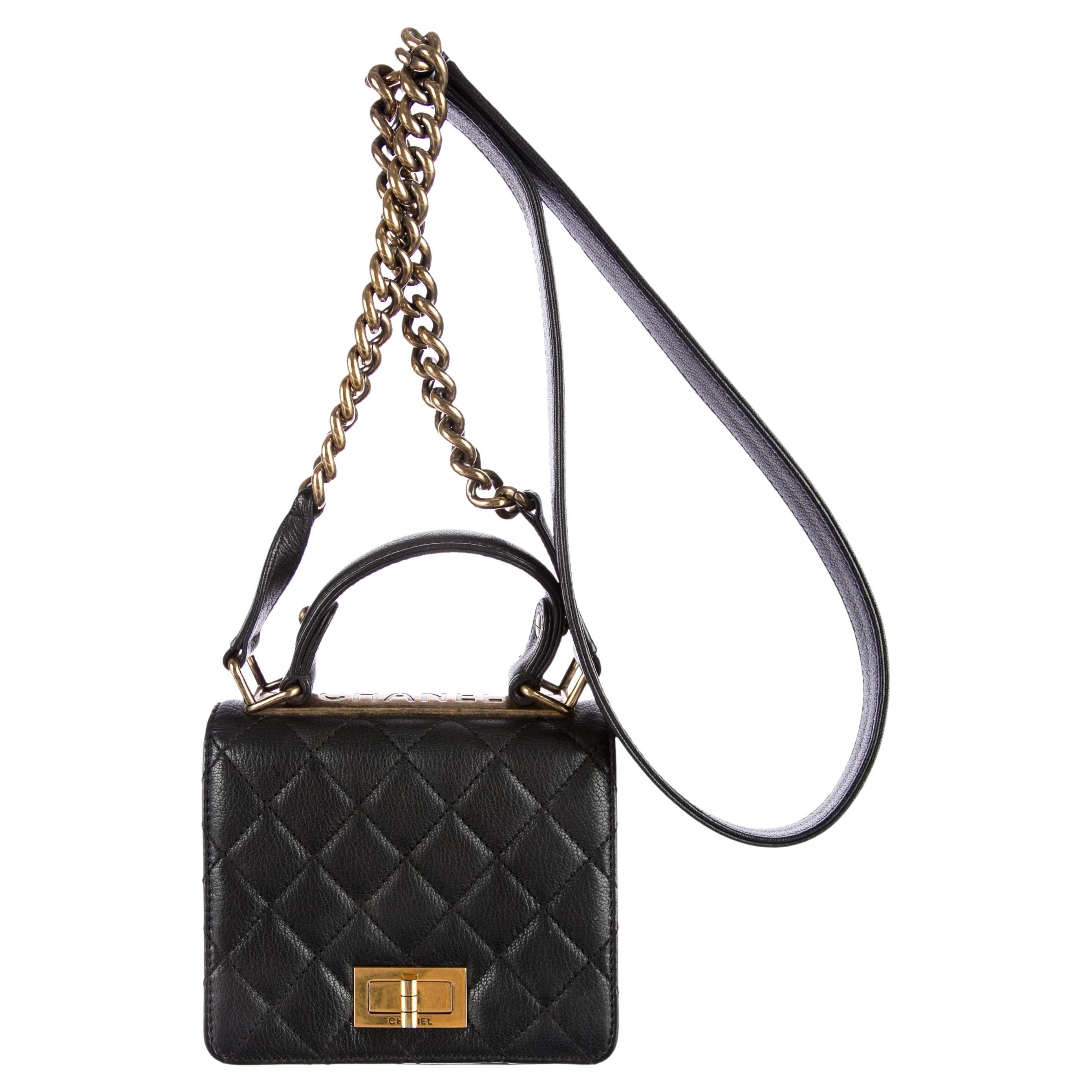 Chanel Small Mini Kelly Top Handle Quilted Caviar Reissue Classic Flap Bag 

Year: 2013

Antique gold hardware

Black quilted caviar leather 
Top handle mini kelly with faux reissue turn lock
Embossed 'CHANEL' across top of bag 
Chain link shoulder