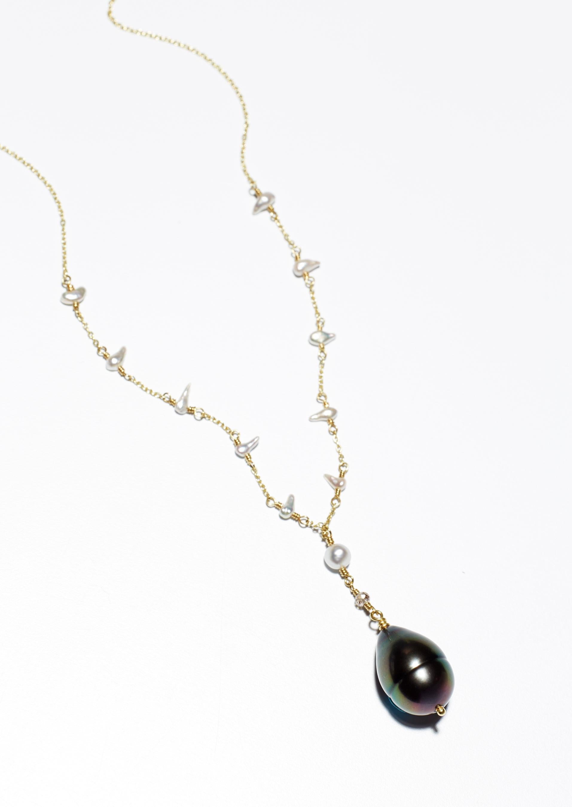 Black Tahitian and white South Sea keshi pearl and diamond necklace. One of a kind, handmade in 18K gold by jeweler Christopher Phelan. 
Length of necklace 17 inches. Pearl quality  and details: Large Tahitian black peacock pearl size 18 x 12.65