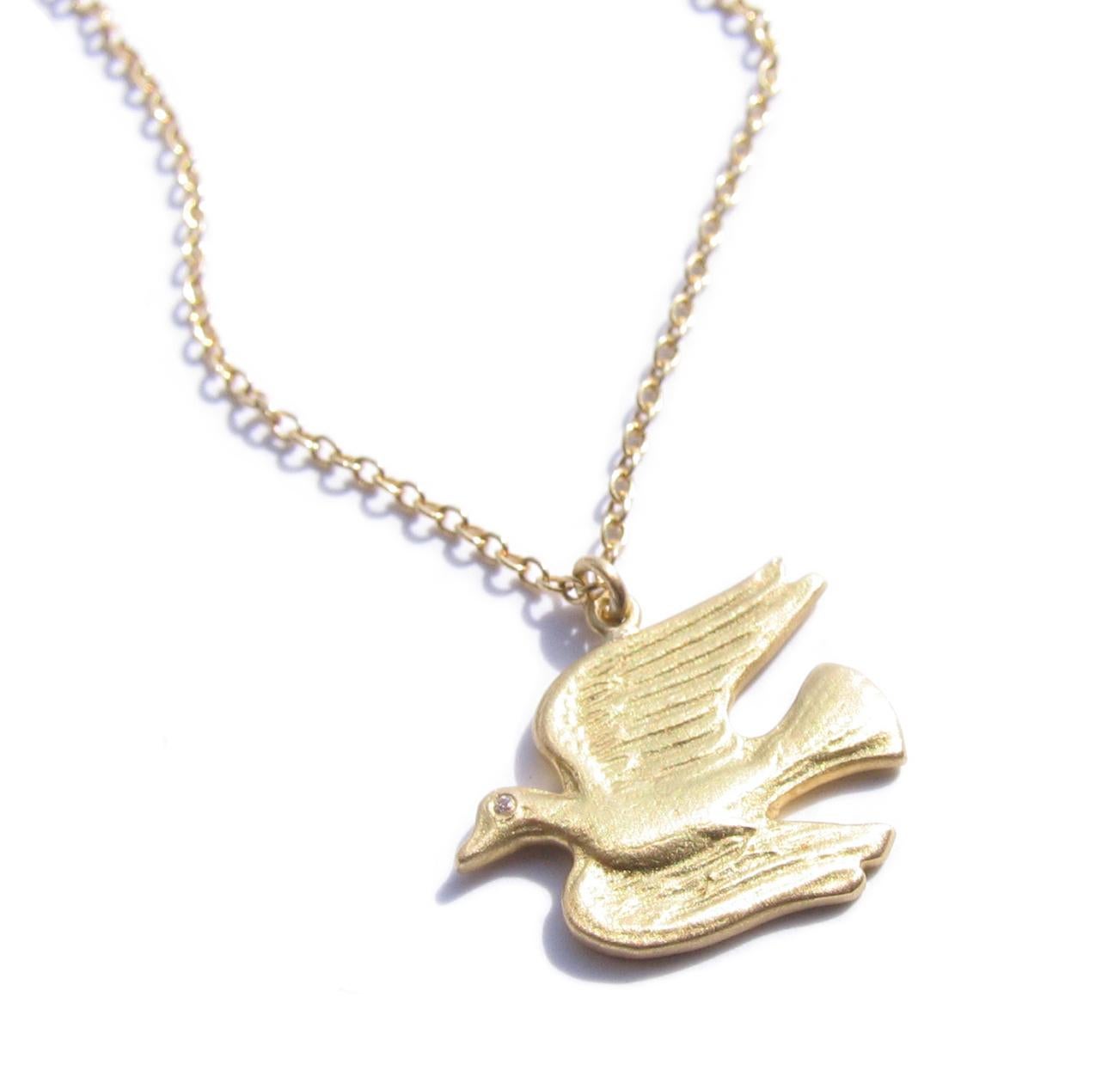 18K Gold flying dove pendant necklace accented with one VS1 diamond.
 Total diamond weight .004 carats. Diameter of dove is ½ X ½  Inches.
 By NYC jeweler Christopher Phelan.
Length of chain measures 16 inches long.

