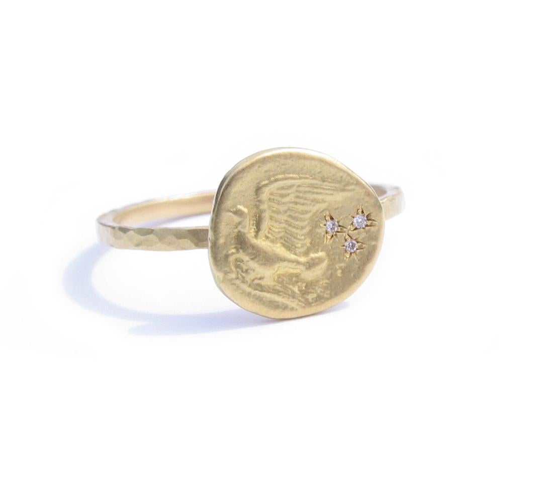 Dove flying in stars 18K gold ring set with 3 brilliant full cut white diamonds. 
By Christopher Phelan Fine Jewelry.
Diamond weight .002 carats. 
Diameter of ring is 10.23 mm. Band width 1.37.
Ring size 5 ¾ . Can be special ordered in any size.

