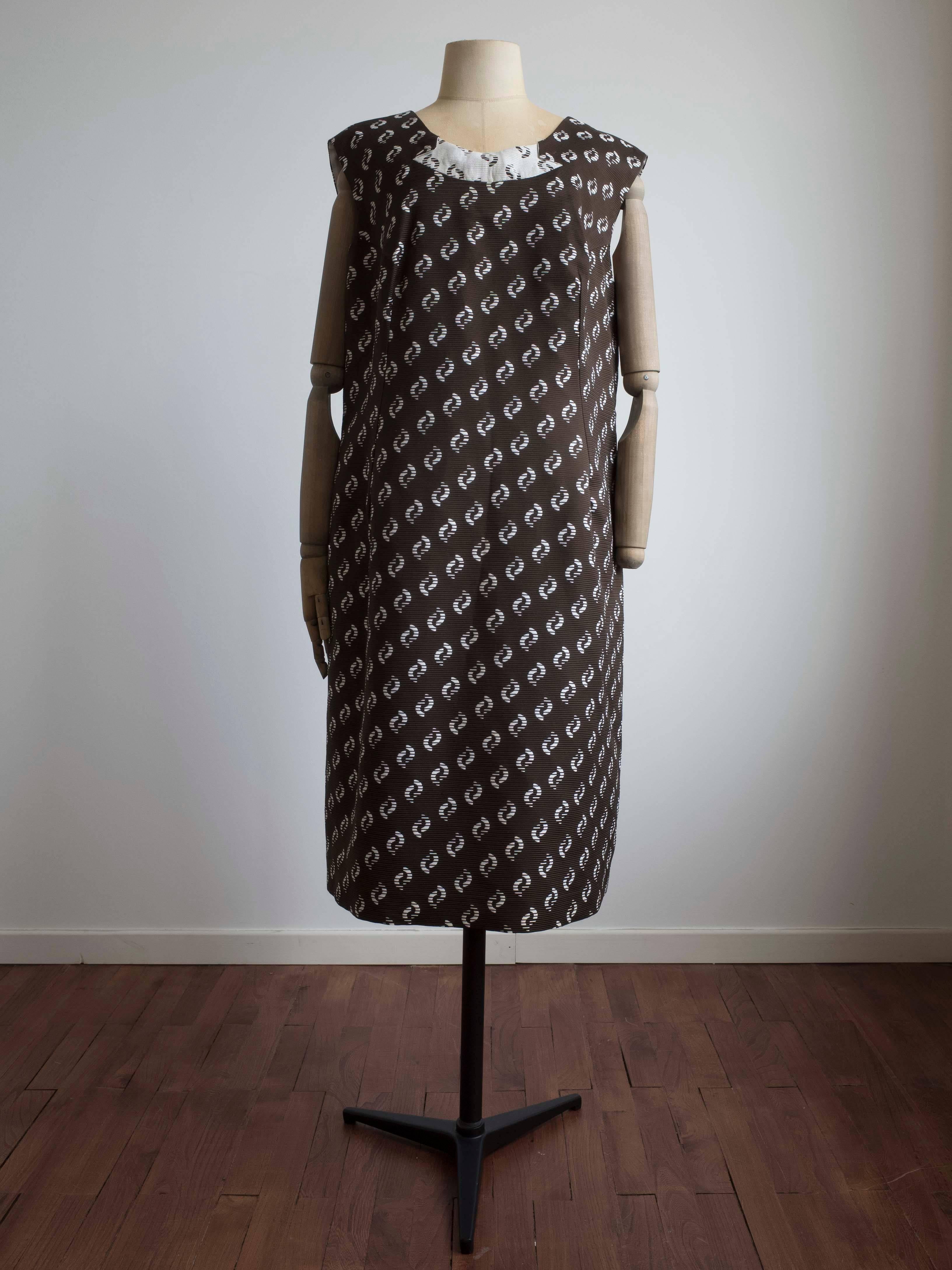 1960s Swing coat and matching shift dress.
All over print in a chocolate brown with white abstract shapes. Matching contrast accents in white reverse print.
The coat features decorative slit sleeves and pearl and silver accent buttons.
The dress is