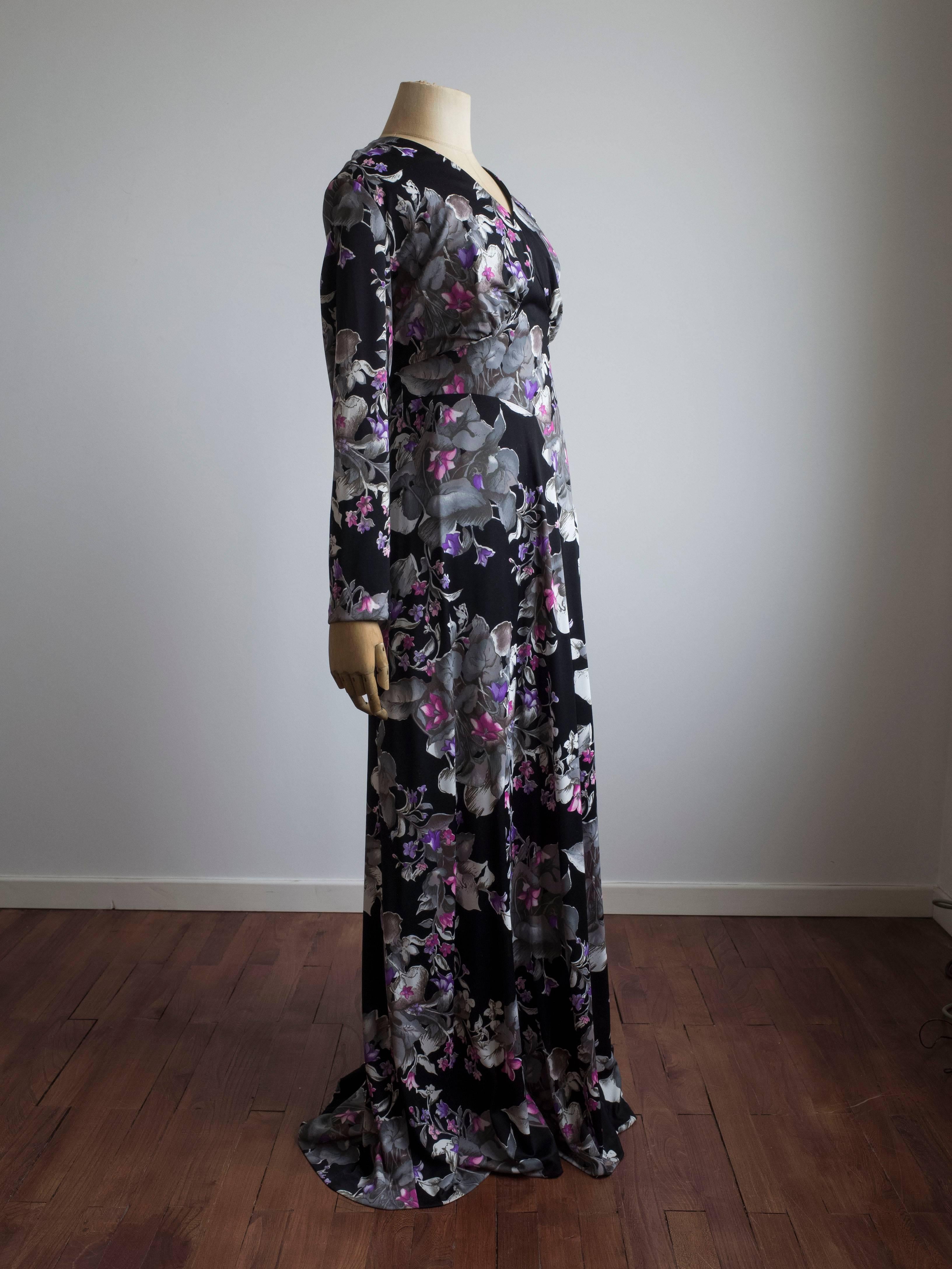 1960s Long sleeve gown by Maison Rigah, Amsterdam.
Never been worn - still has original tags.

All over black, pink and purple floral print. 
Features long ties to secure and accentuate the waist.
Full back zip. Fully lined.
Outer: 100%