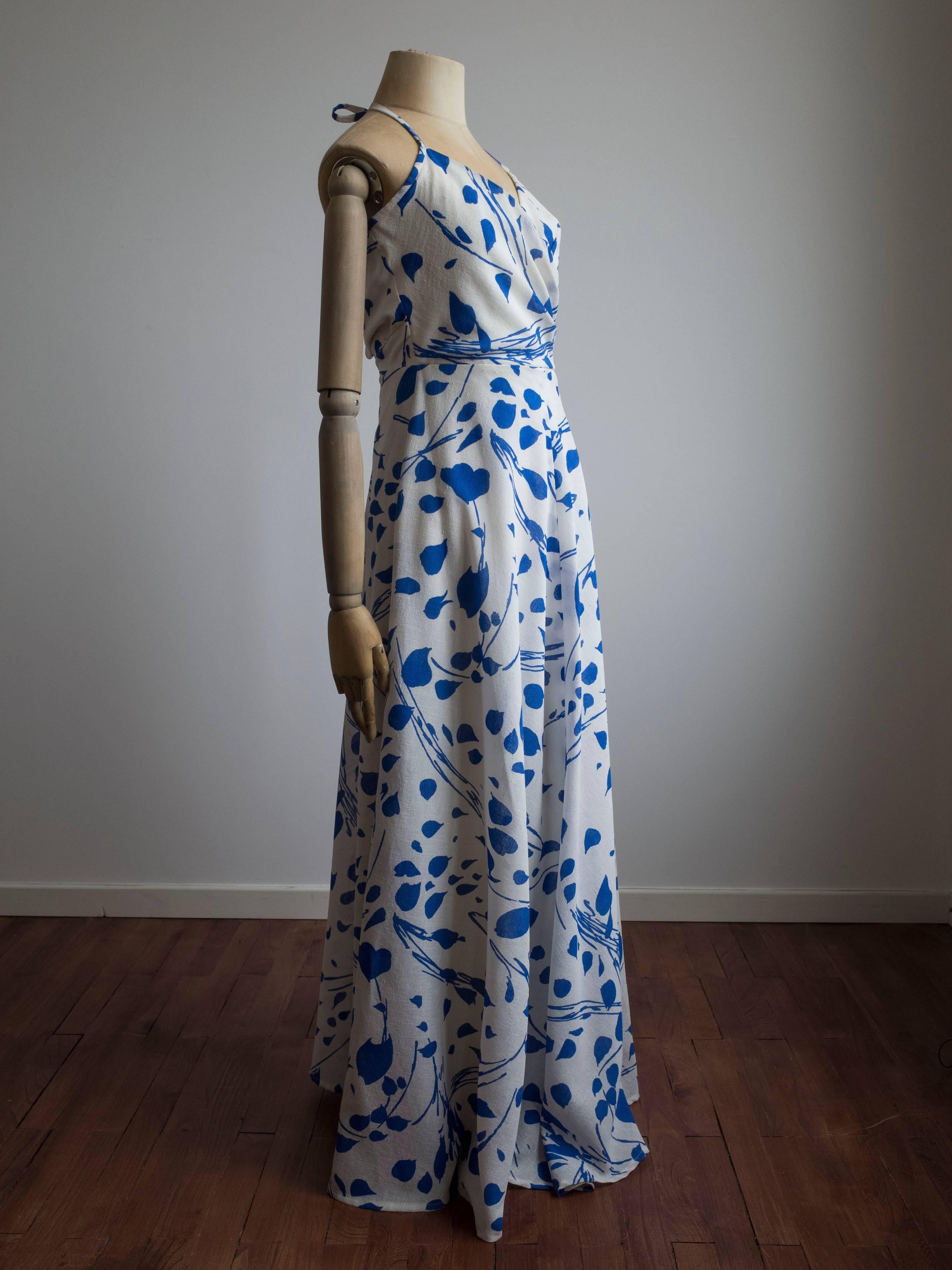 1960s blue and white floral print dress by Jean Allen. Made in London, England. Never been worn - still has original tags.
Halter style neckline with cross-over bust and pleating at the waist. The full circle skirt is bias cut with beautiful