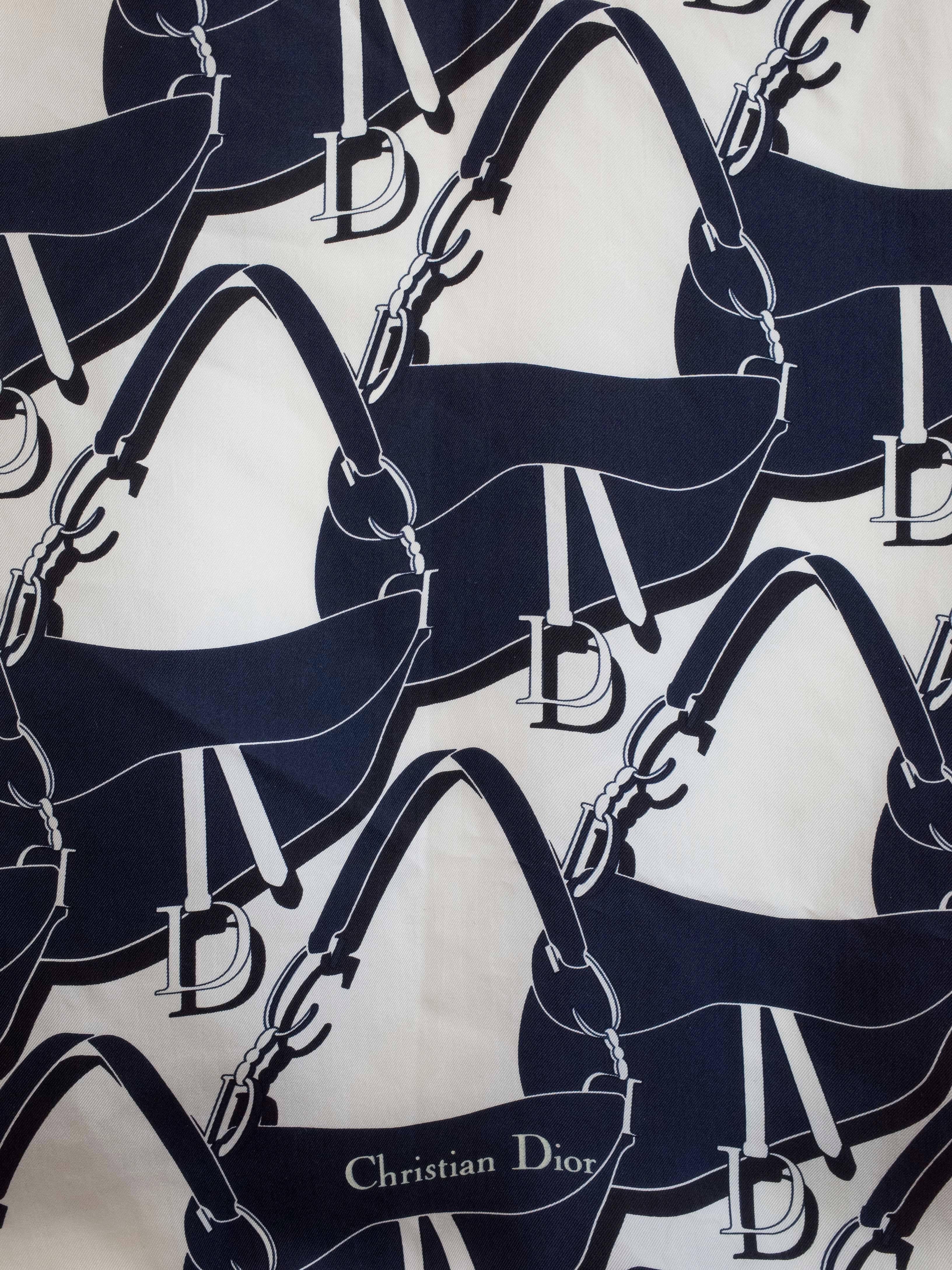 Silk scarf by Christian Dior. 
Features a navy and white over-all print of the iconic saddle bag.
Measures 34” square

