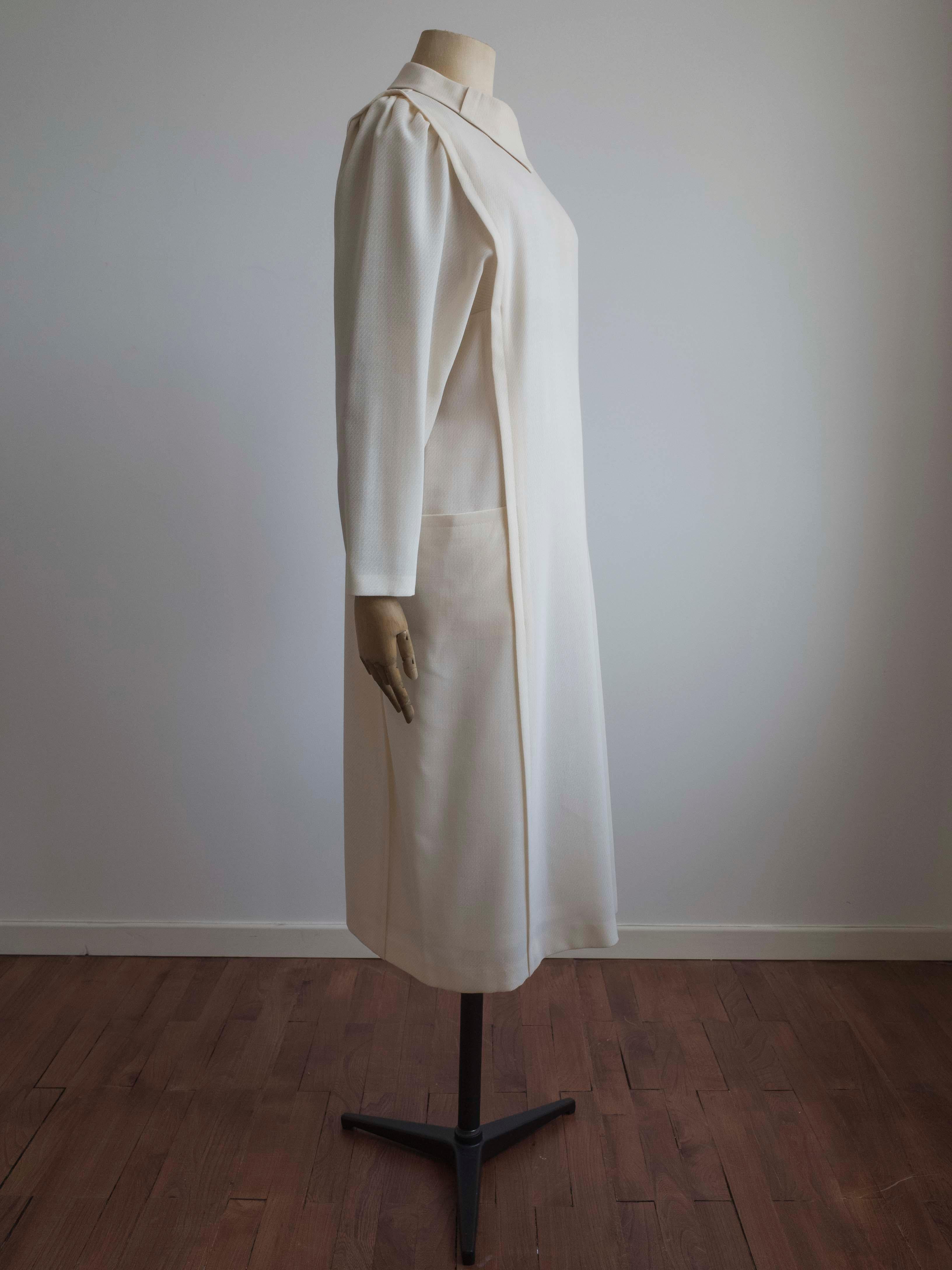 Vintage 1960s dress in a soft cream wool blend by Schworm Modell.

Features pleated dolman sleeves and side pockets. Fully lined with zipper at centre back.
This dress has been professional cleaned.

Outer: 45% Wool, 55% Polyester
Lining: 100%