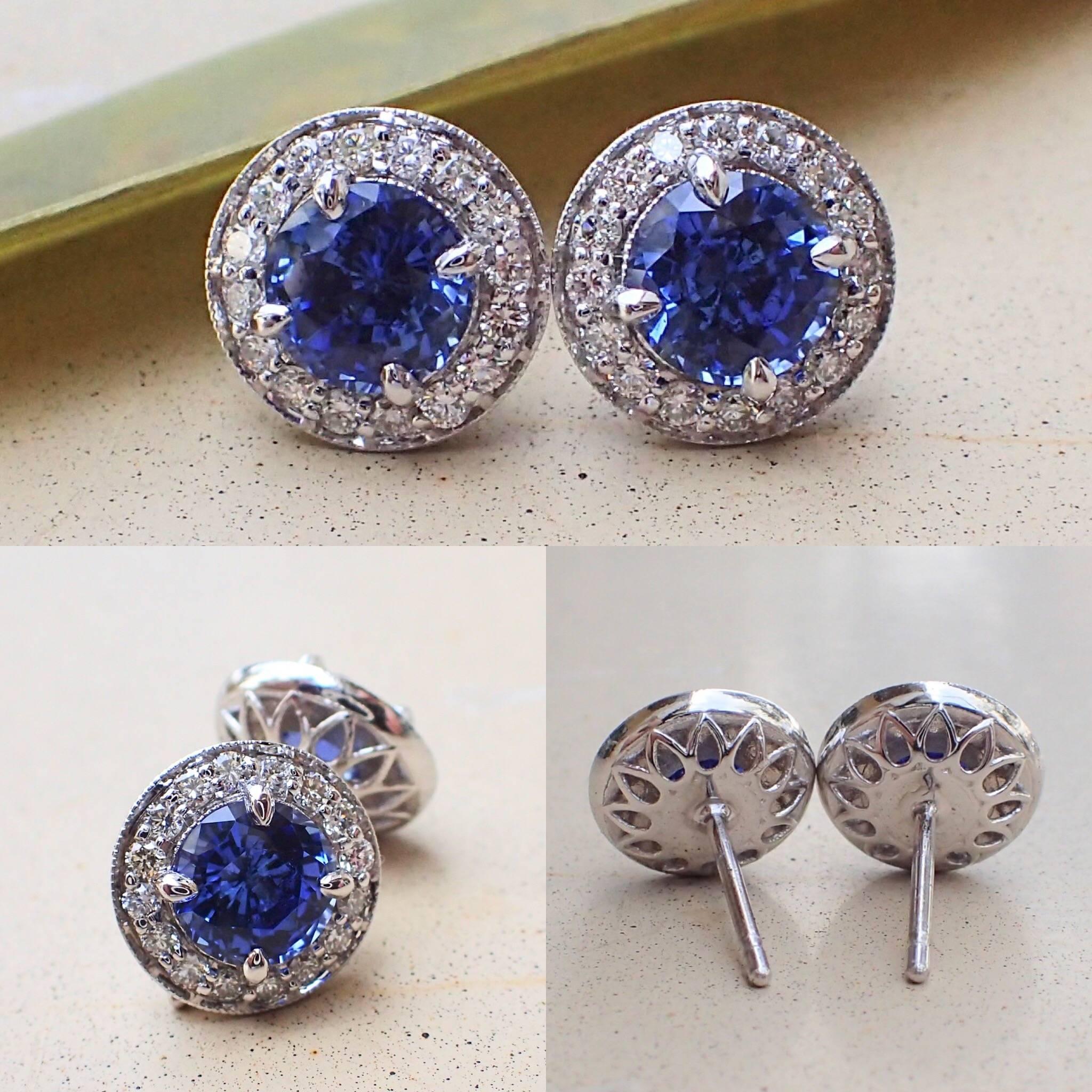 A pair of 18k white gold earrings are set with two (2) Round Brilliant Cut Chatham-Created Blue Sapphire that measure 6.0mm x 6.0mm and weigh a total of 2.21 carats with Clarity Grade VVS-VS and thirty-two (32) Round Brilliant Cut Diamonds that