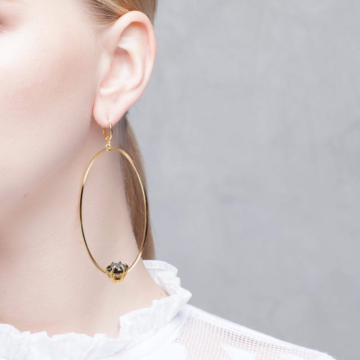 Puro Iosselliani presents its iconic creole big hoop earrings. Made in 18 Karat gold plated silver, the big hoops float effortlessly by a lever back vintage hook. A reversed black round zircon embellishes the hoop for extra shimmering. 6,5 cm