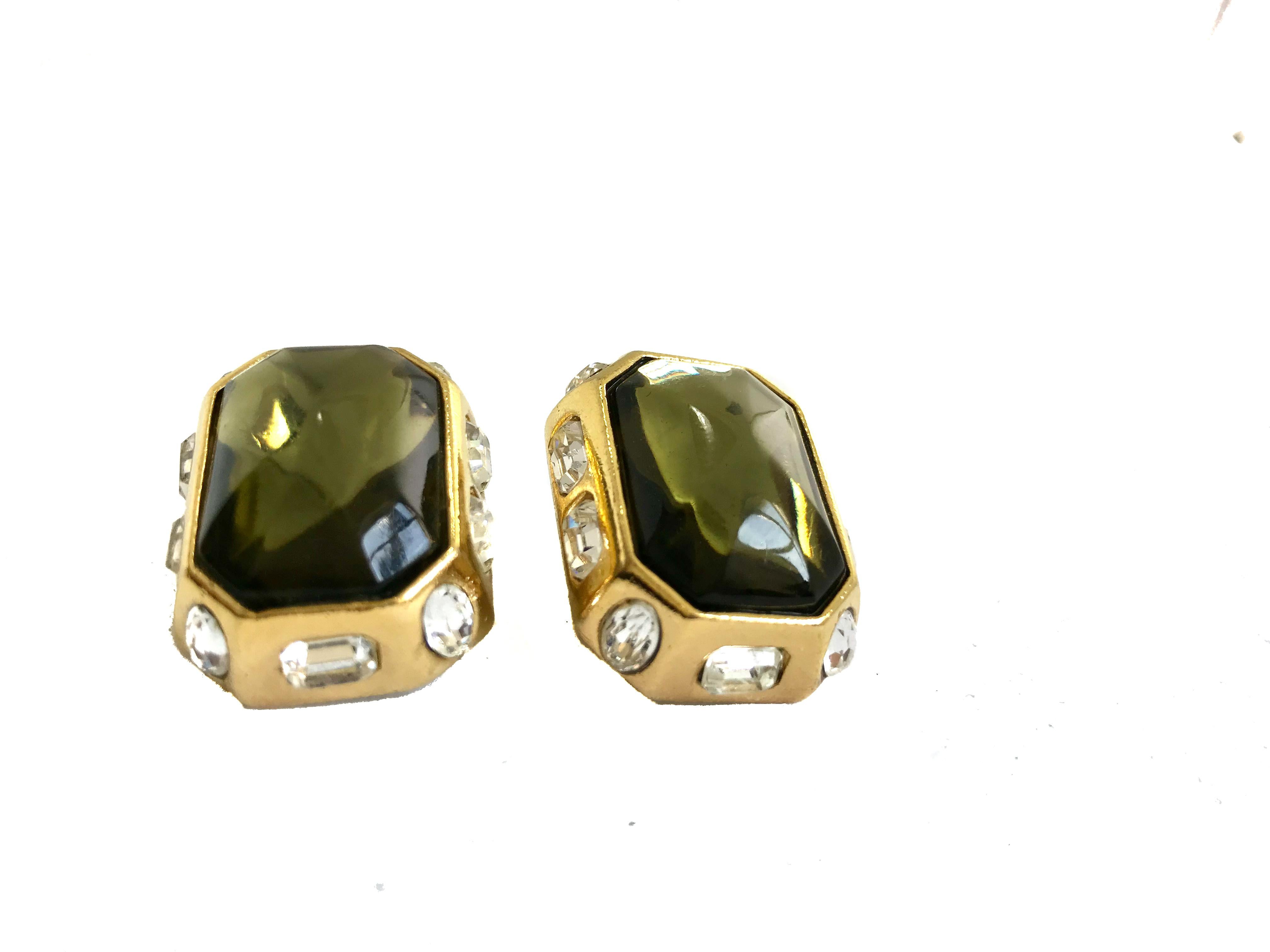 YSL 1980s Vintage Statement Clip On Earrings with large green stone and smaller crystals inset into the surrounding gold plated metal.

Turn heads with these classic showstoppers!
 
Excellent condition.

1 inches x 0.75 inches