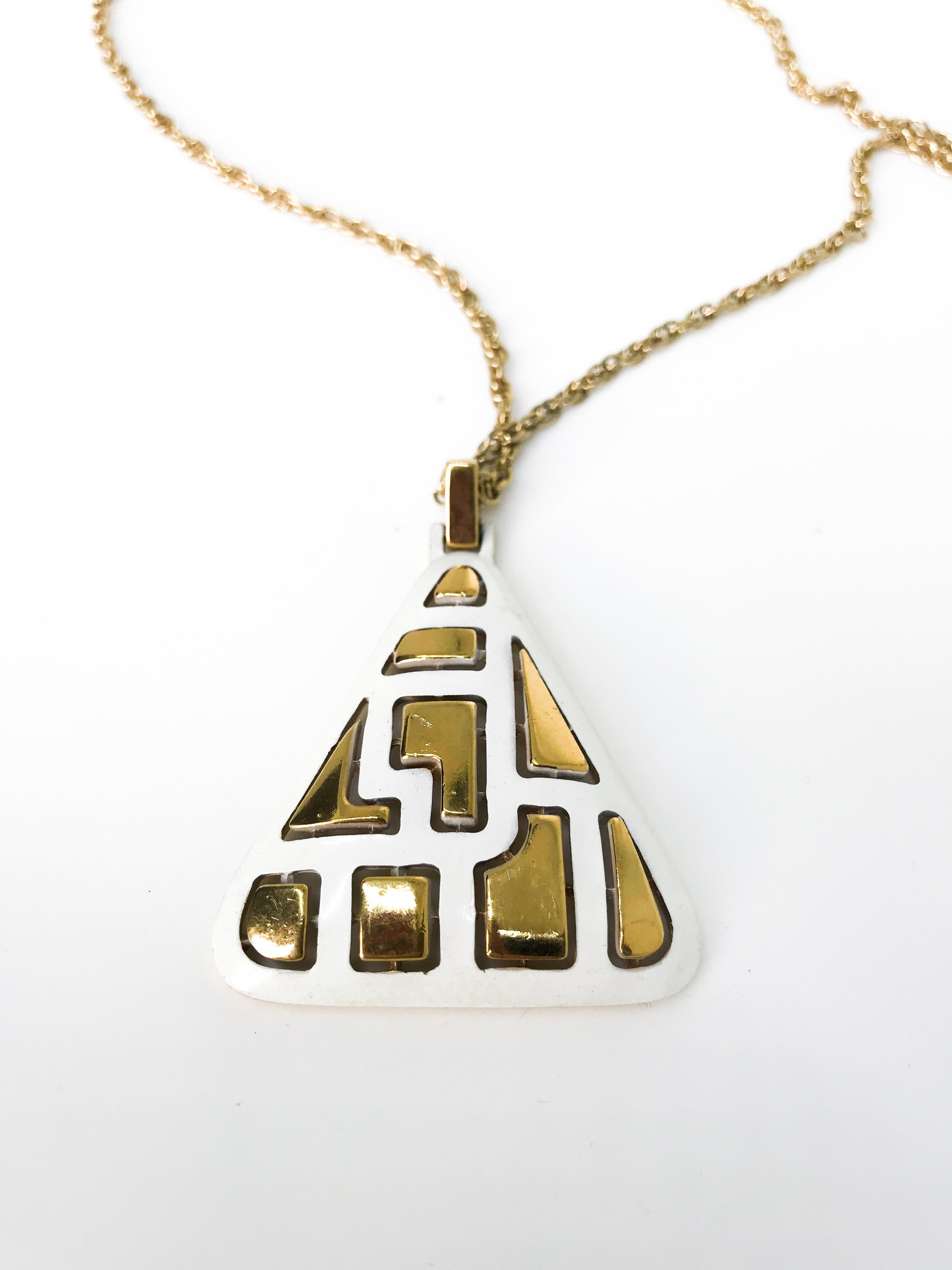Crown Trifari 1970s vintage modernist white and gold tone pendant.  Signed on reverse of pendant as well as featuring the classic Crown Trifari hang tag on the clasp.

Excellent condition.

Dimensions 
length - approx 24 inches
pendant width - 2