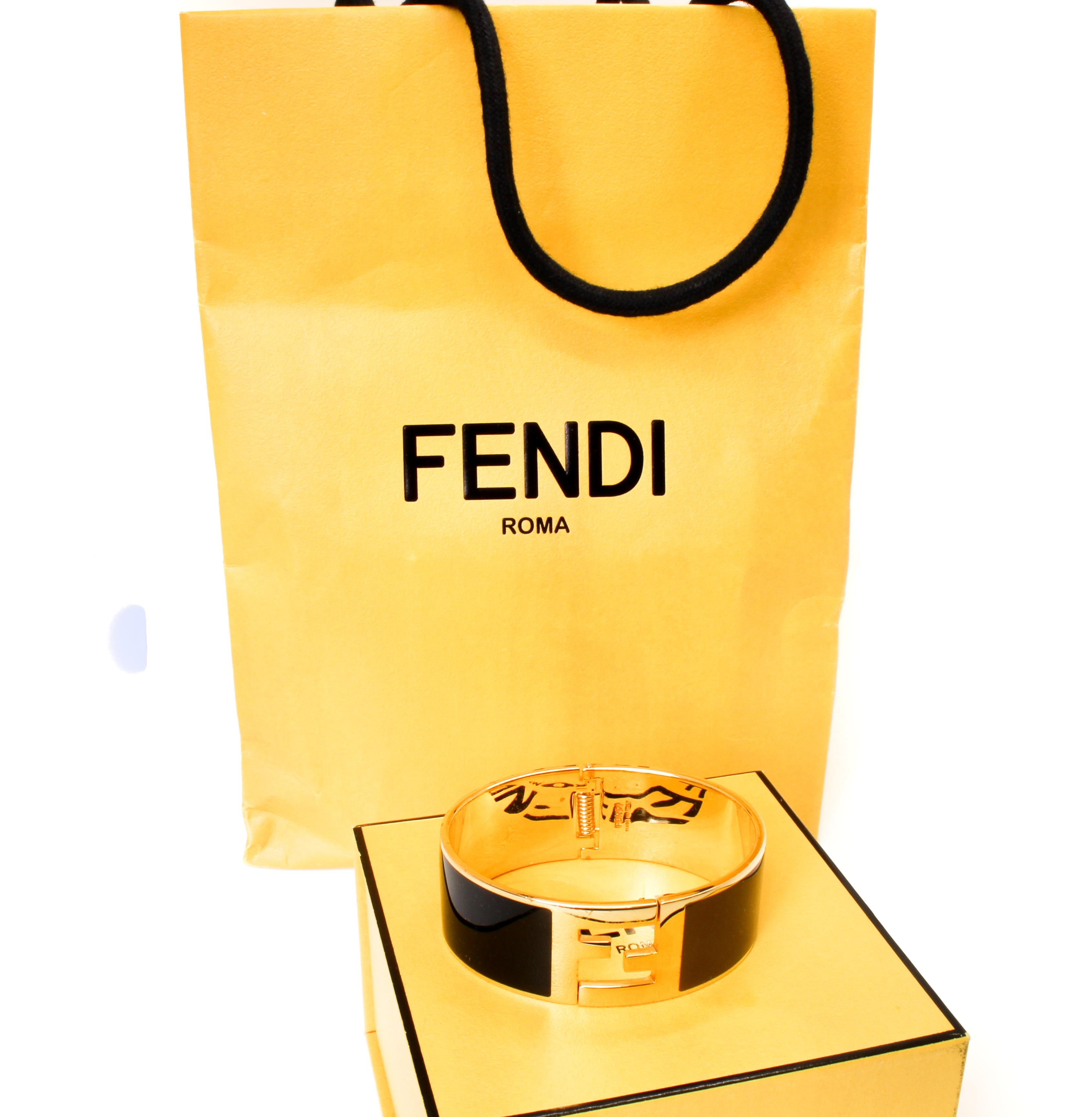 Fendi 'Fendista' enamel cuff bracelet with FF logo closure.

Made out of gold tone metal and blue and brown enamel. Fendi is engraved on the inside. 

Made in Italy.  Comes with orignal box and bag.
 
Measurements: Circumference 6