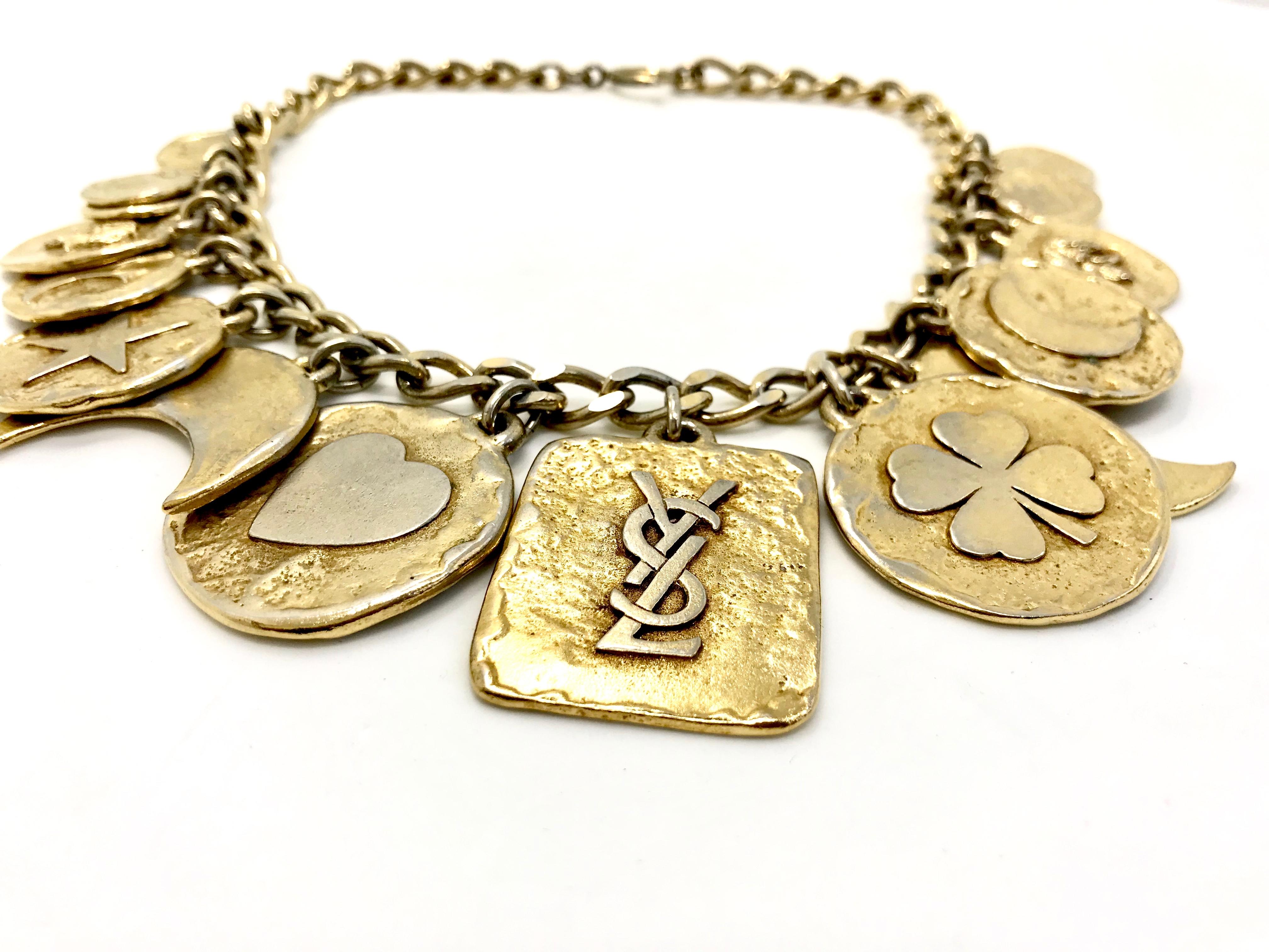 Iconic YSL /  Yves Saint Laurent 1980s vintage charm necklace.  

Features heart, star, dove, lily, moon, clover charms - a real statement 80s YSL piece for the discerning collector.

Main YSL- tag on necklace measures 4 by 3.7cms, so the