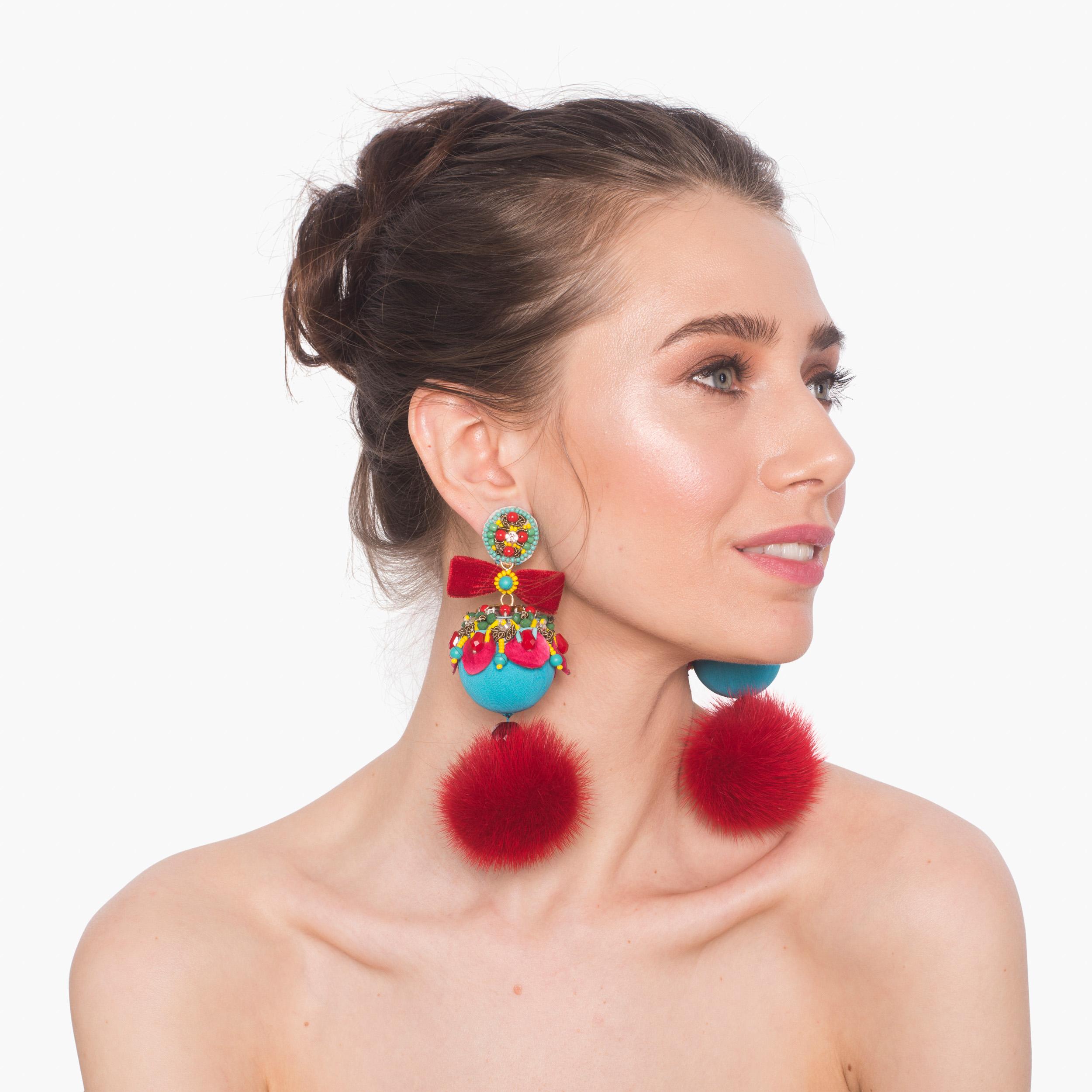Make a playful statement in the Marataruna earring. Mink fur pompoms, glass beading, and velvet bows give Marataruna of pop of color for a flirtatious flair. 
