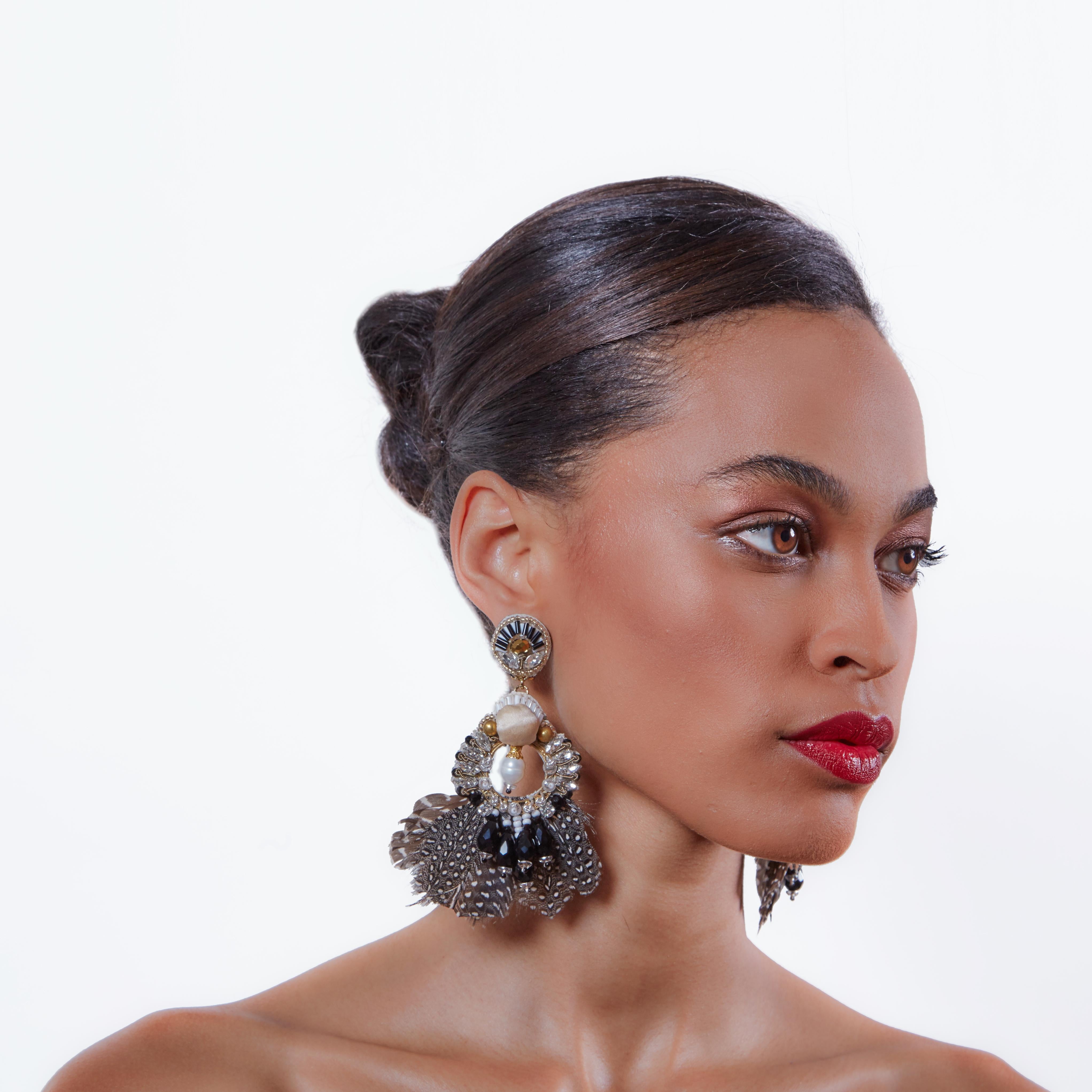 Make a subtle statement with the Carambola earring. Adorned with Mother-of-Pearl and Guinea feathers, Carambola makes the perfect statement for Fall. 