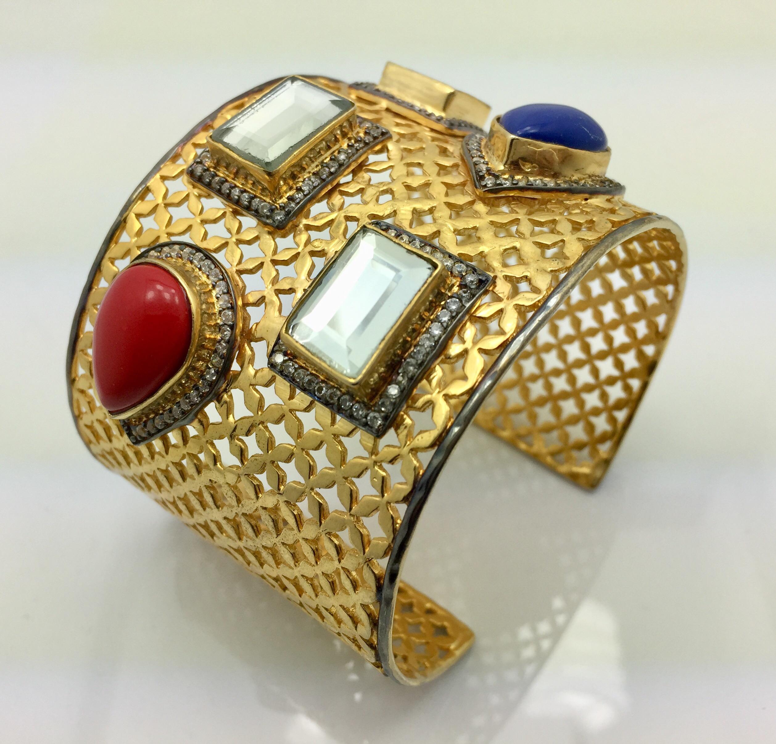 A gold lattice frame with light reflecting mirror polki stones becomes a gleaming backdrop for the brightly colored blue and red teardrop stones.  The wide cuff is an attention commanding finishing touch you will treasure, and is slightly adjustable