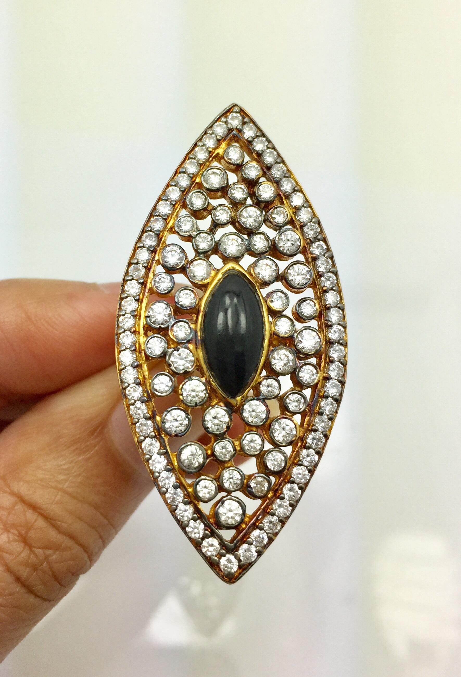 The evil eye, thought to provide protection from evil spirits is beautifully captured in this gold, black and CZ evil eye cocktail ring. The large ring, which spans from knuckle to knuckle, is lavishly adorned with sparkling CZ stones - the backdrop