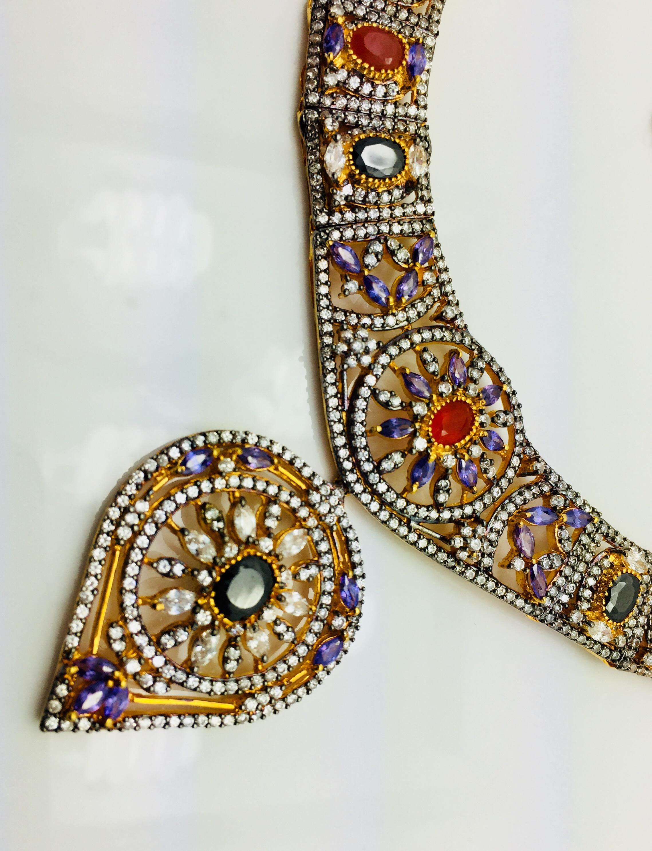 Un pezzo straordinario con dettagli intricati.  Impreziosito da zirconi, cristalli rossi, neri e finta ametista. Solo 1 disponibile.

SEGUI  Visita la vetrina di Meghna Jewels per vedere l'ultima collezione e i pezzi esclusivi.  Meghna Jewels è