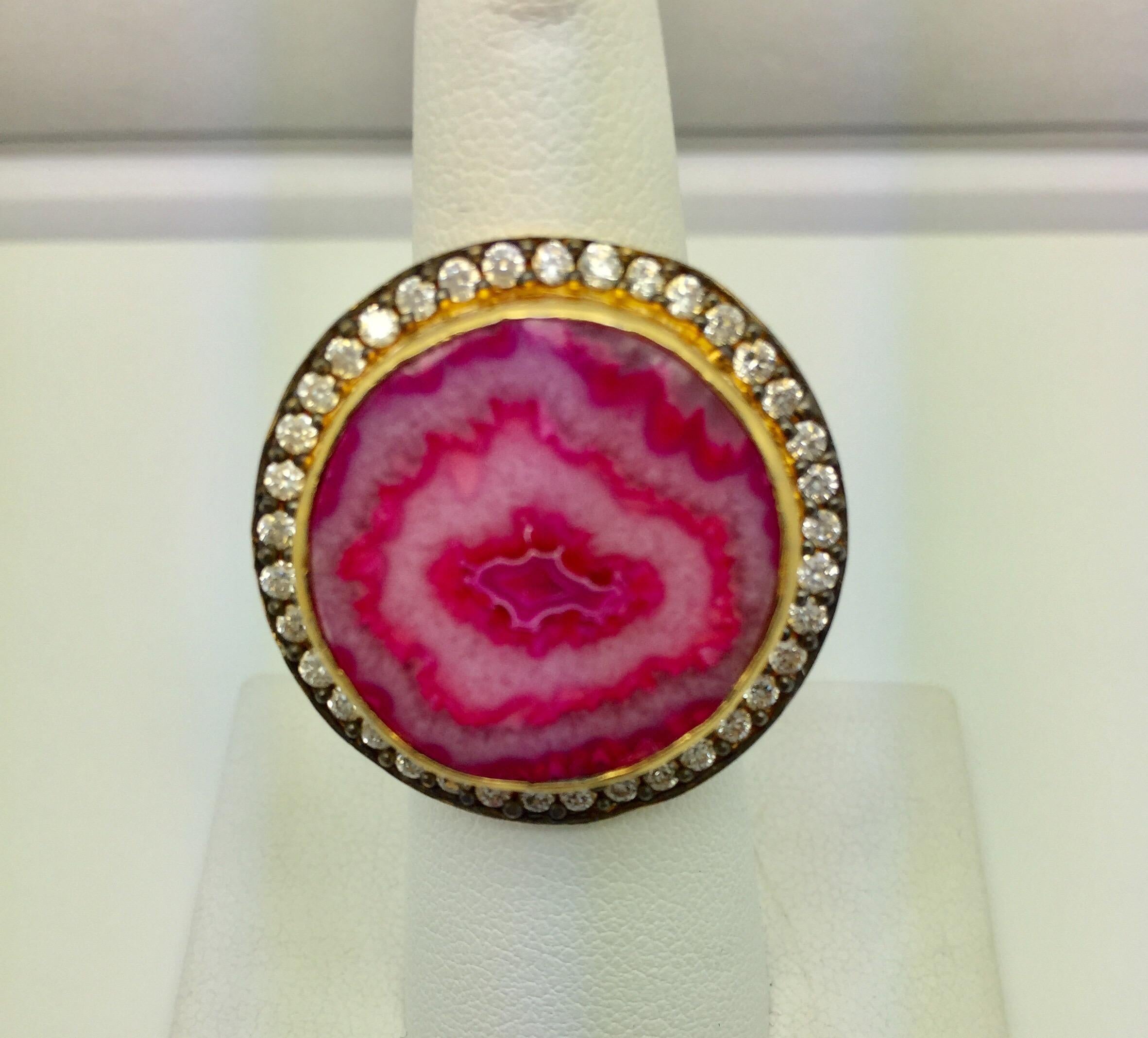 The brilliance of the stone sits perfectly within a sparkling CZ border, in this pink agate druzy ring. Artisan craftsmanship is evident in this superbly finished ring that you will be proud to wear.  Available in ring size 7 & 8.  More color