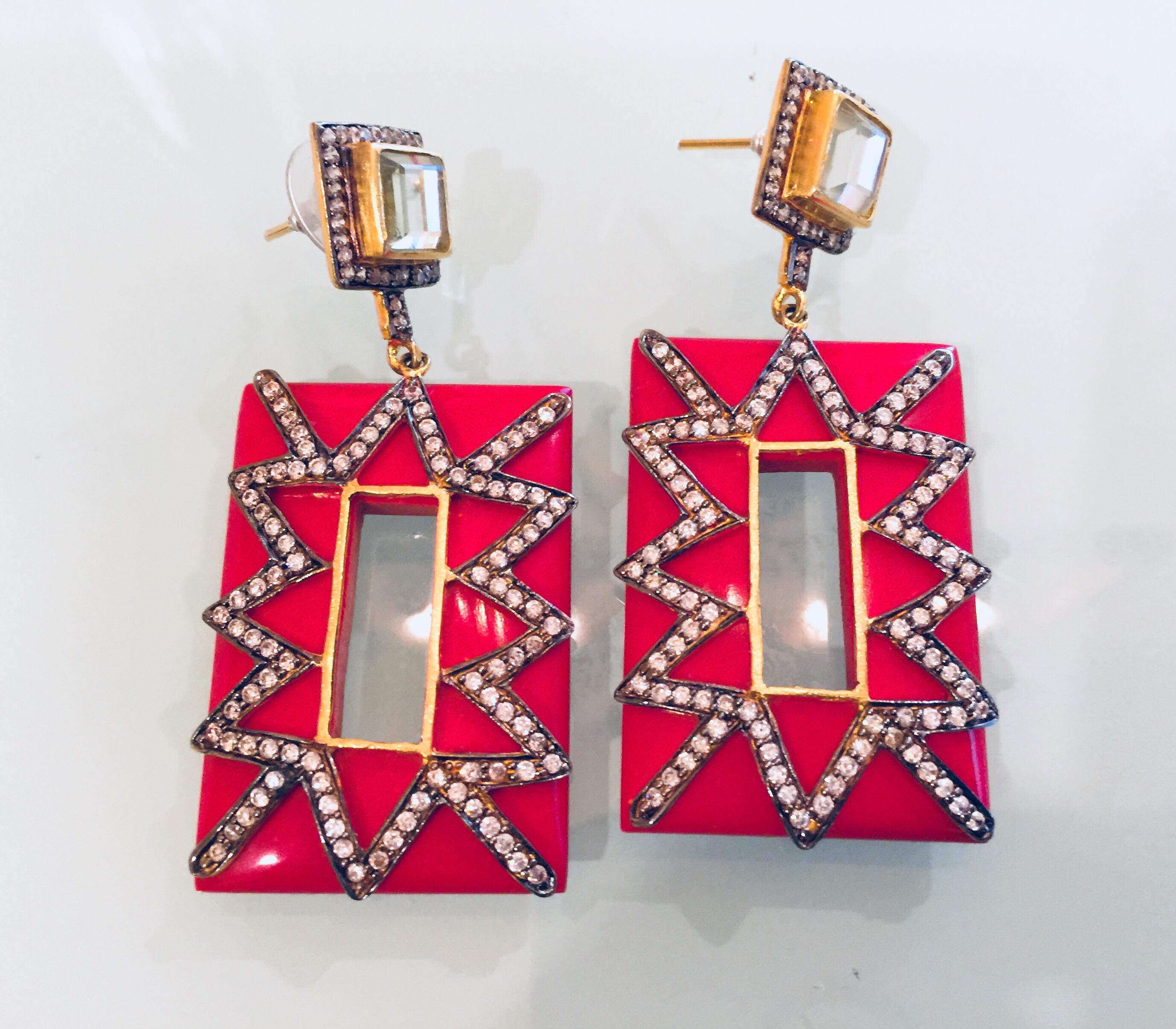 Gorgeous gold, red and cubic zircon Audrey earrings. A thick red, rectangular outline is enhanced with rows of zigzag CZ stones for a dazzling sparkle fest. The clear, square crystal at the top is surrounded by small CZs and supports the post