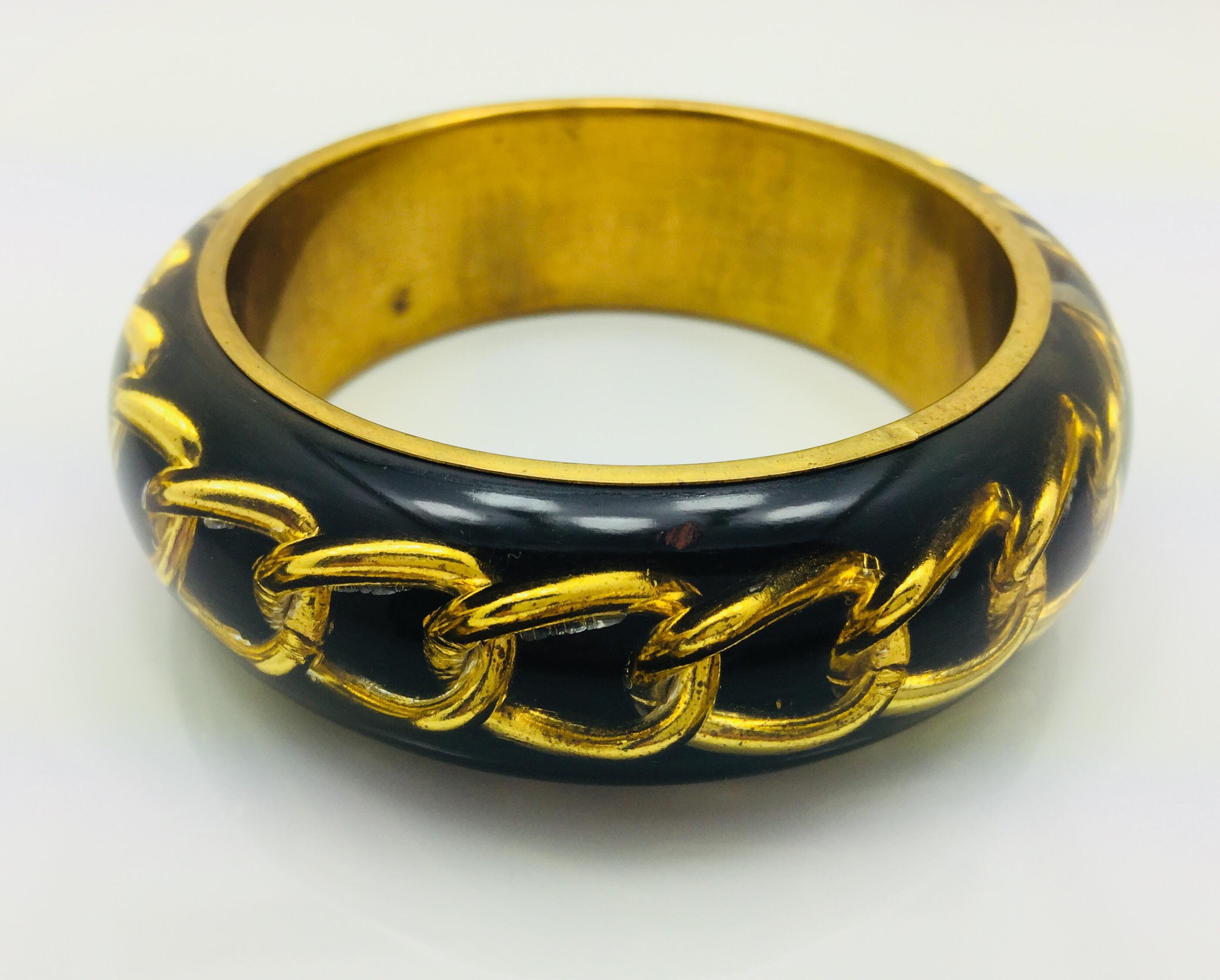 Black Resin bangle bracelet featuring inlaid gold chain. 

Measurements : total diameter approx. 9.1 cm (3.58 inches) / inner diameter approx. 6.4 cm (2.52 inches) / thickness approx. 0.9 cm (0.35 inch).

FOLLOW  MEGHNA JEWELS storefront to view the