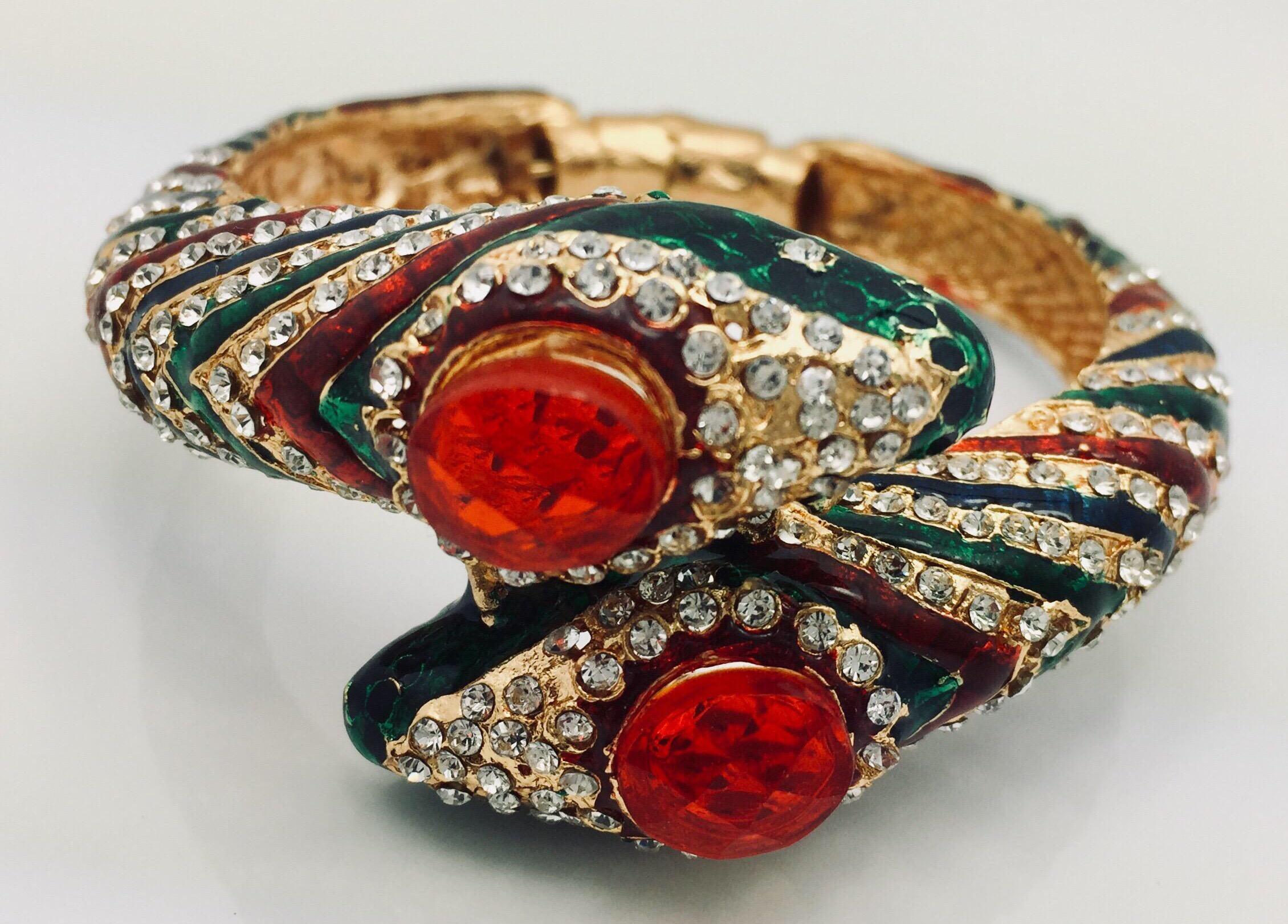 Stunning wrap around snake hinged bangle bracelet is encrusted with sparkling cubic zircon and detailed with bold rich green, red and blue enamel.

Approx: 1.13