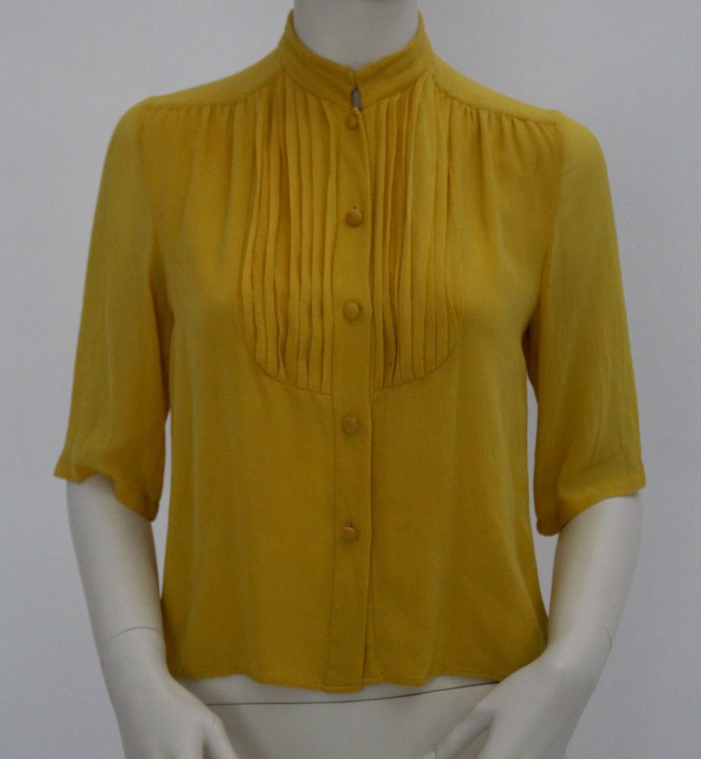 This blouse by Celine was designed in the 1970s and made of 100 % Georgette - Crepe Silk.
Standing collar and decorated with cords
Front button closure
Very good vintage condition 
